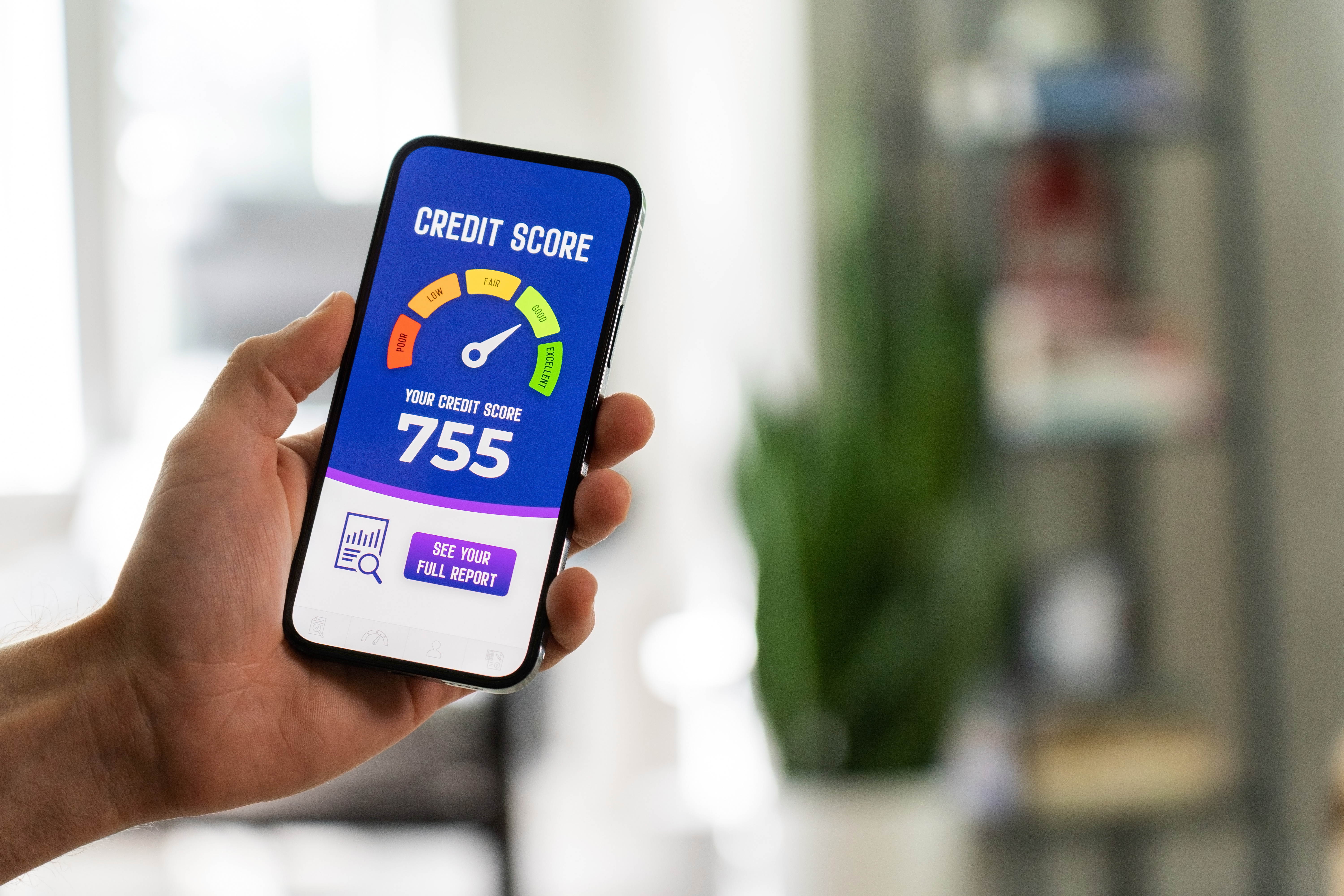 Looking at credit score on phone Person holding a smartphone with good credit score meter on the screen