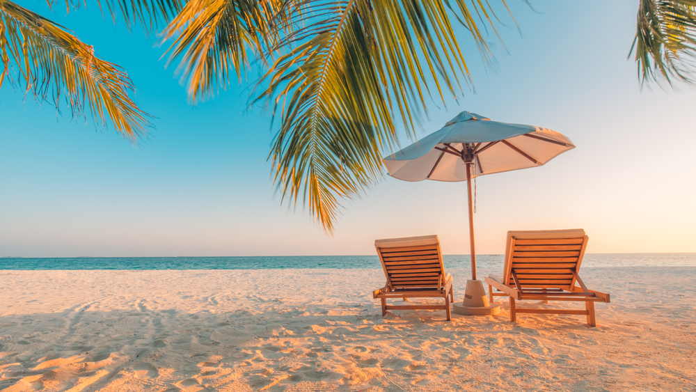 Two lounge chairs and an umbrella on the beach. Two lounge chairs and an umbrella on the beach.