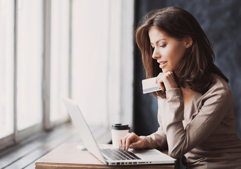 Woman Using Credit Card on Laptop