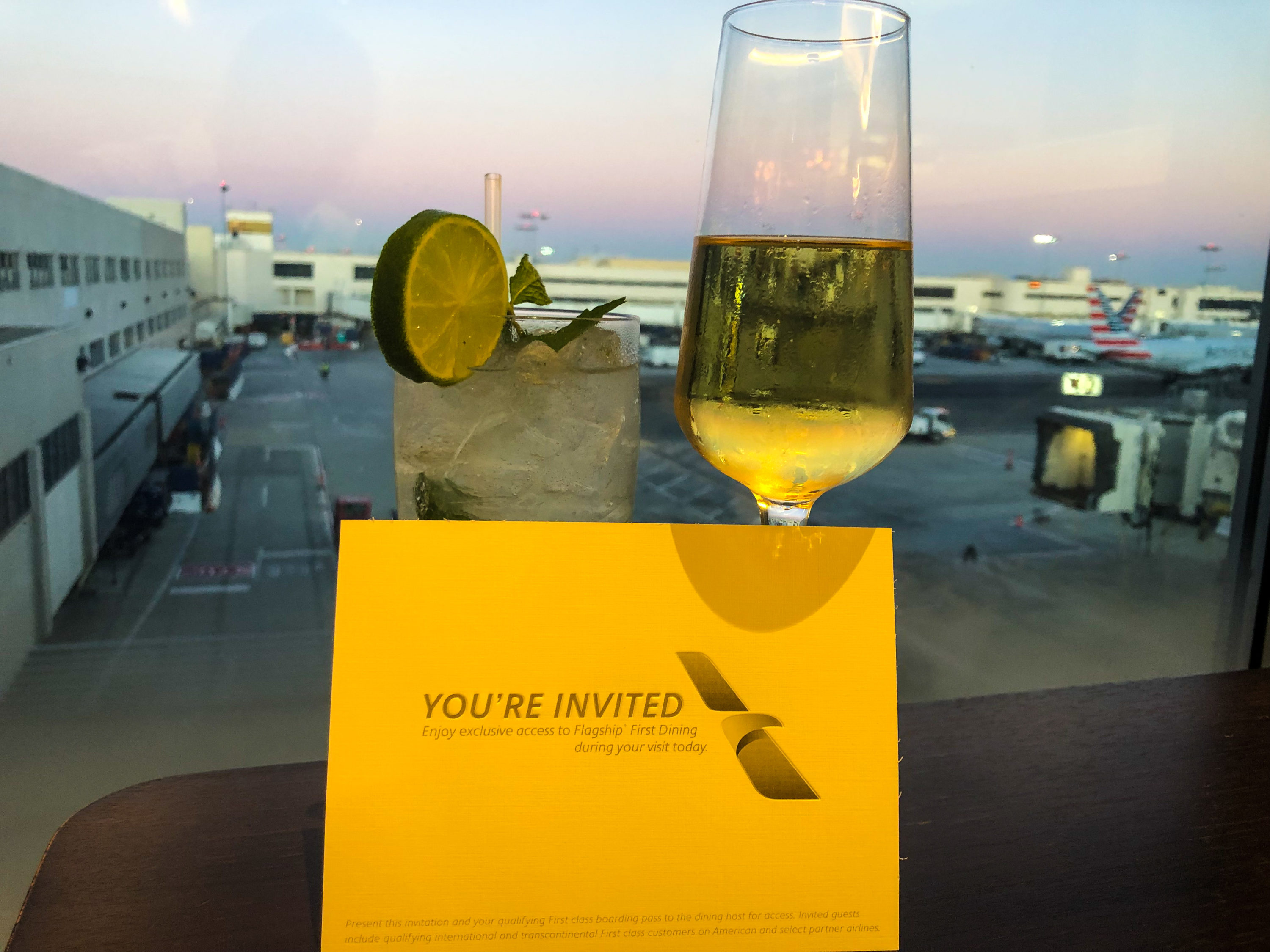 American Airlines Flagship First Dining LAX tarmac view with Krug and mojito