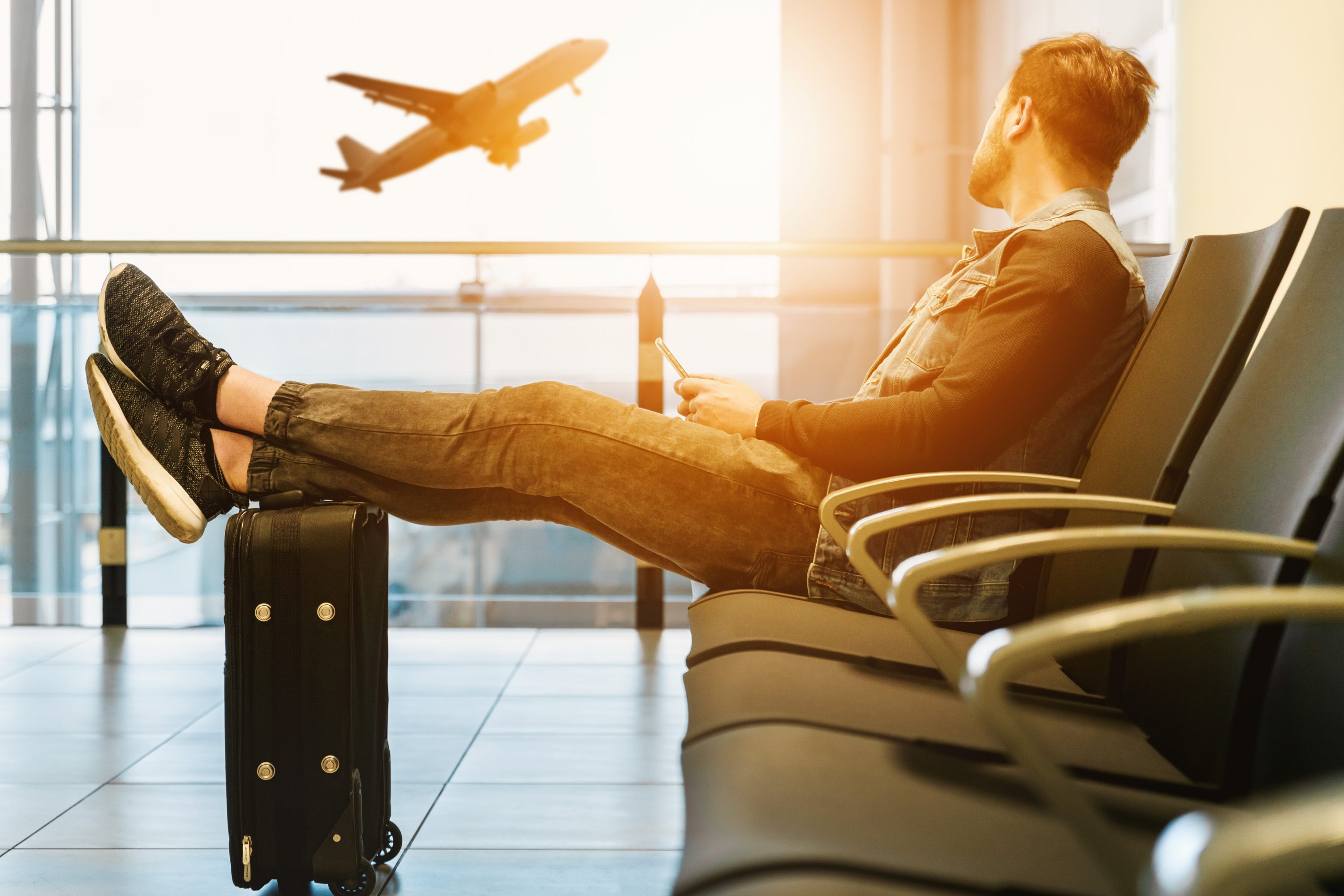 Man Sitting With Suitcase At The Airport Man Sitting With Suitcase At The Airport