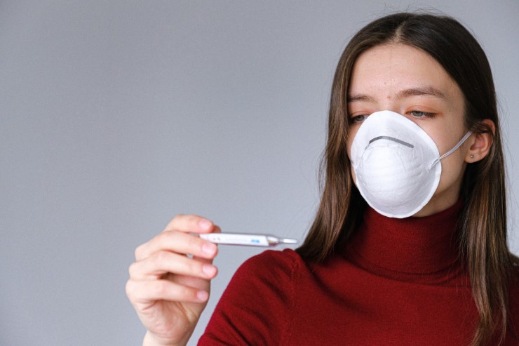 Woman With Fever and Thermometer