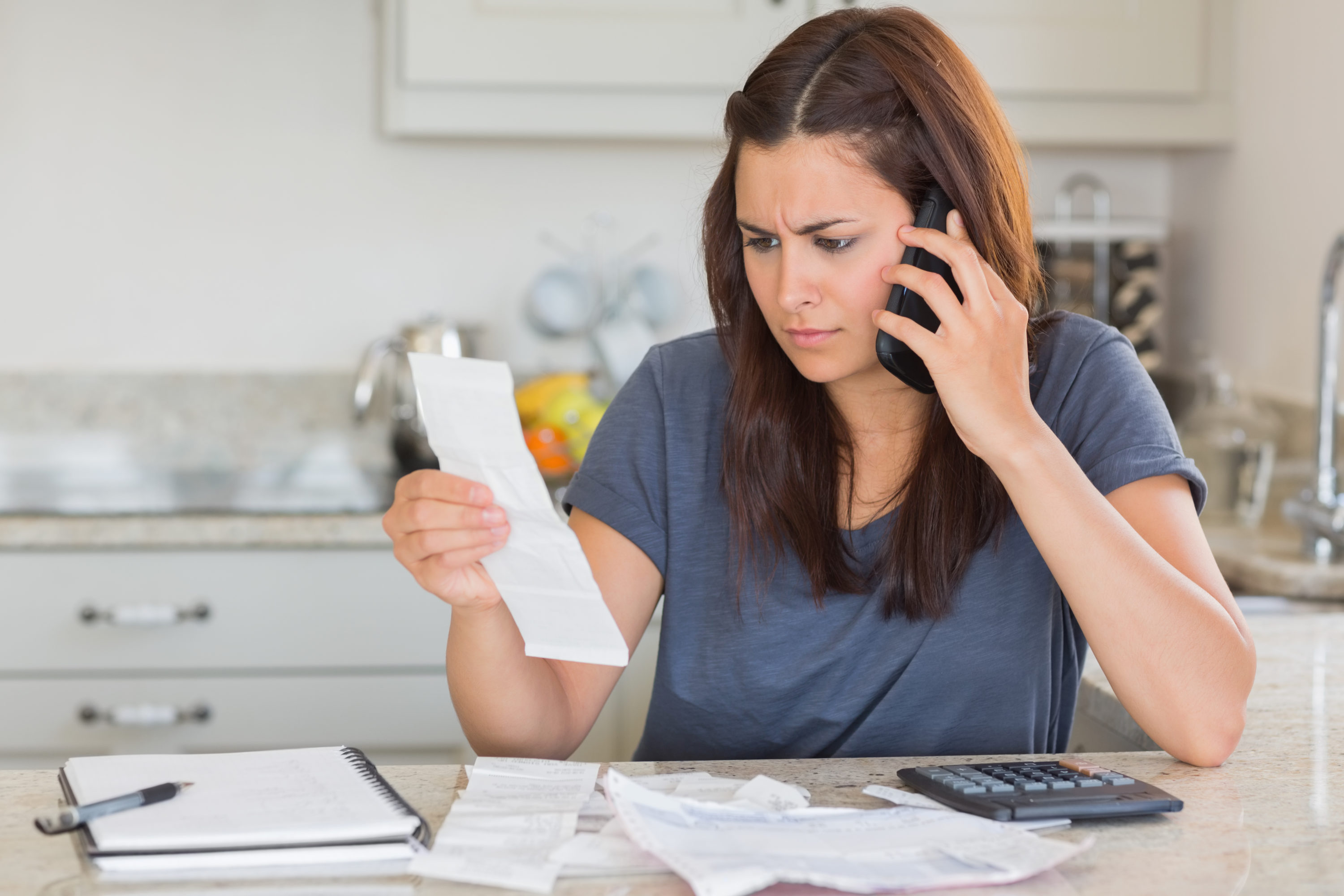 Woman on phone looking at bill