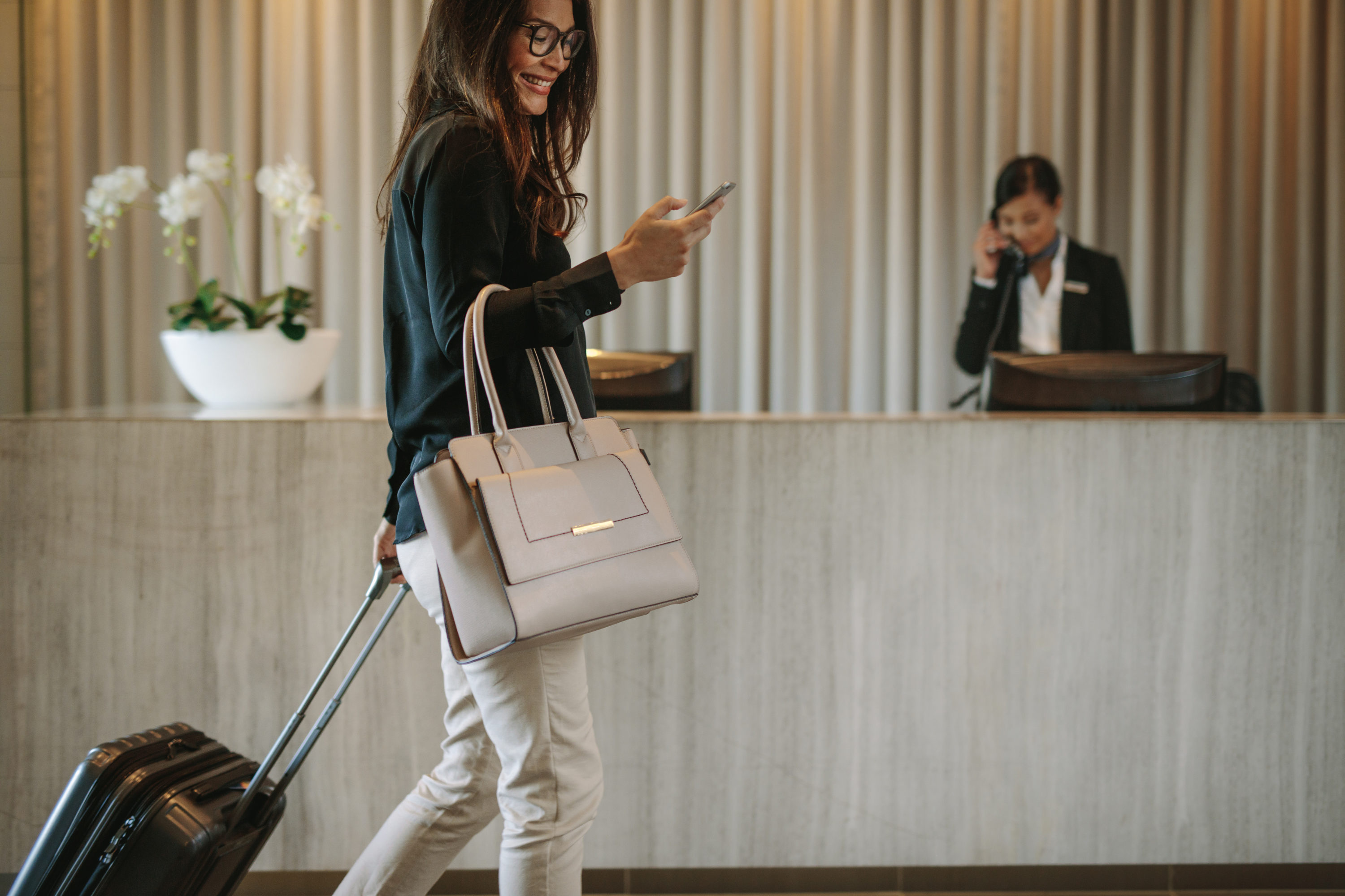 Guest checking phone at hotel check-in desk