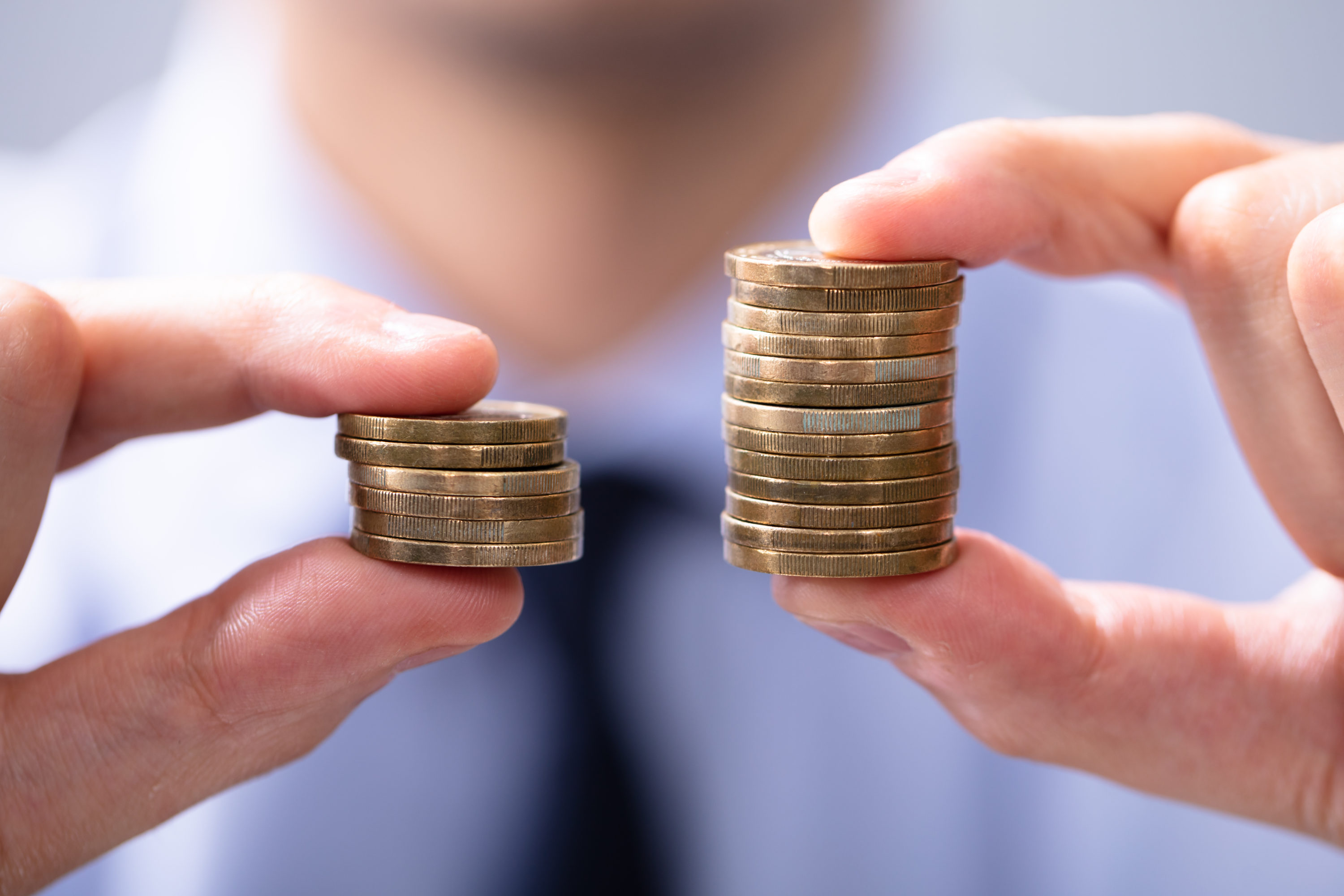 Comparison with stack of coins in each hand