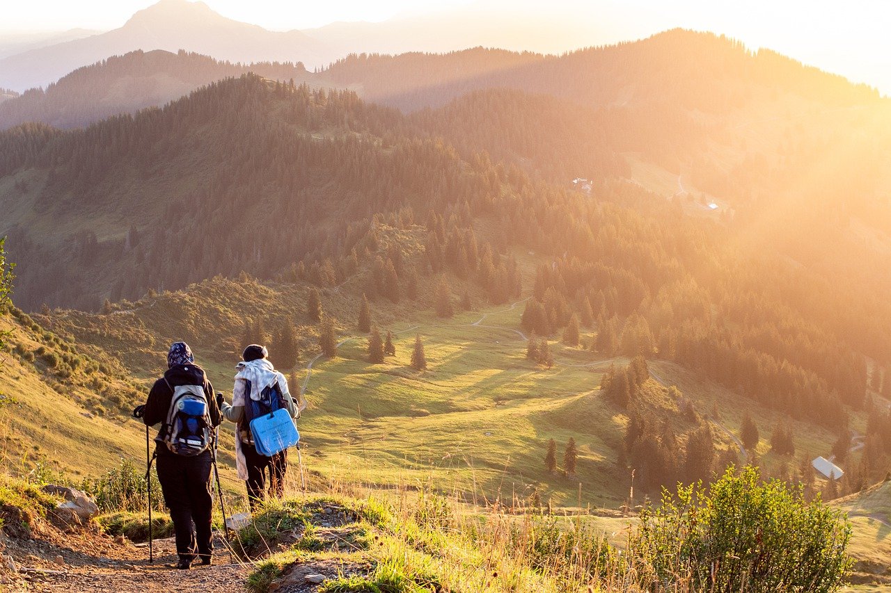 2 people hiking on a grassy mountain