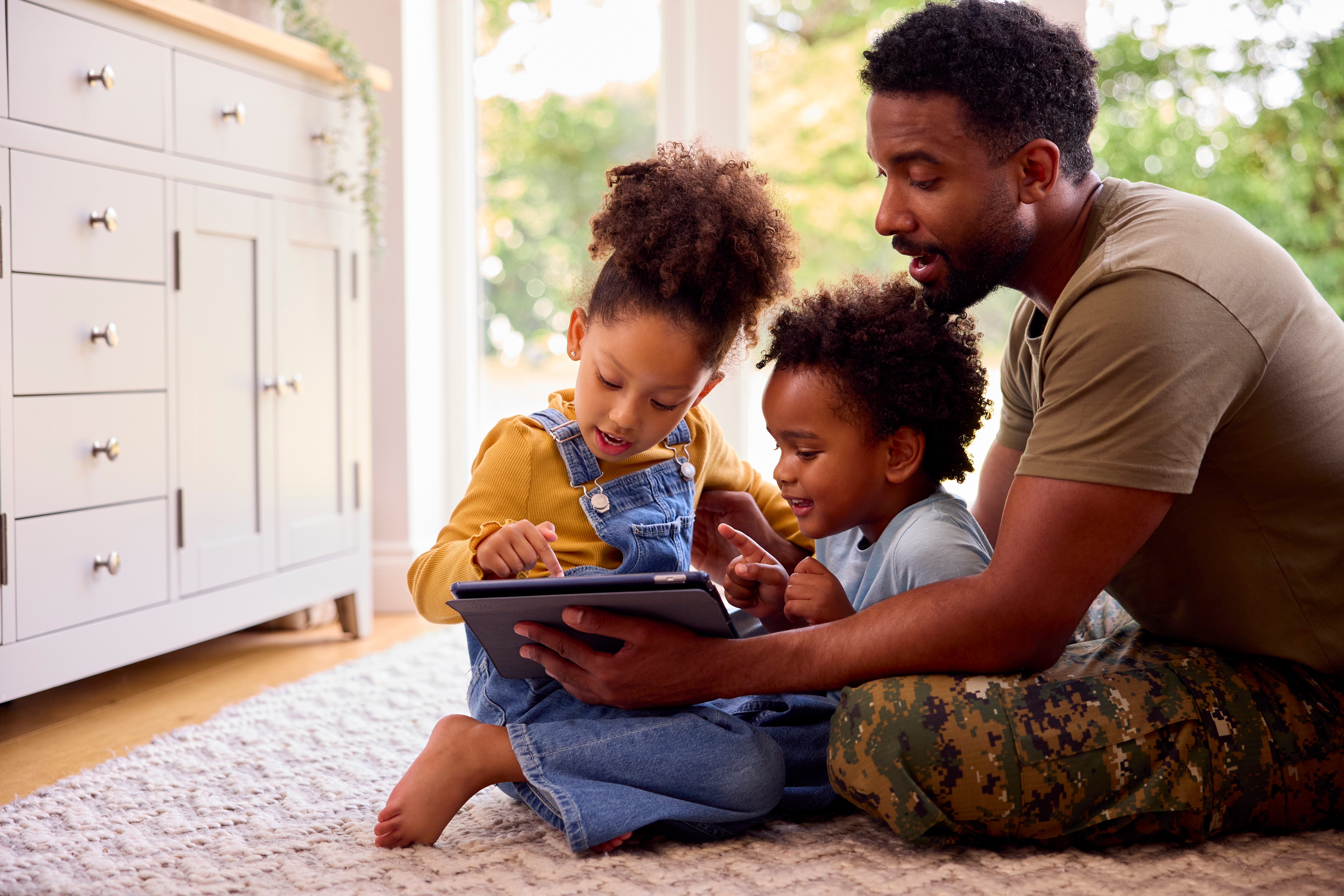 Army Father In Uniform Home On Leave With Children Using Digital Tablet Army Father In Uniform Home On Leave With Children Using Digital Tablet