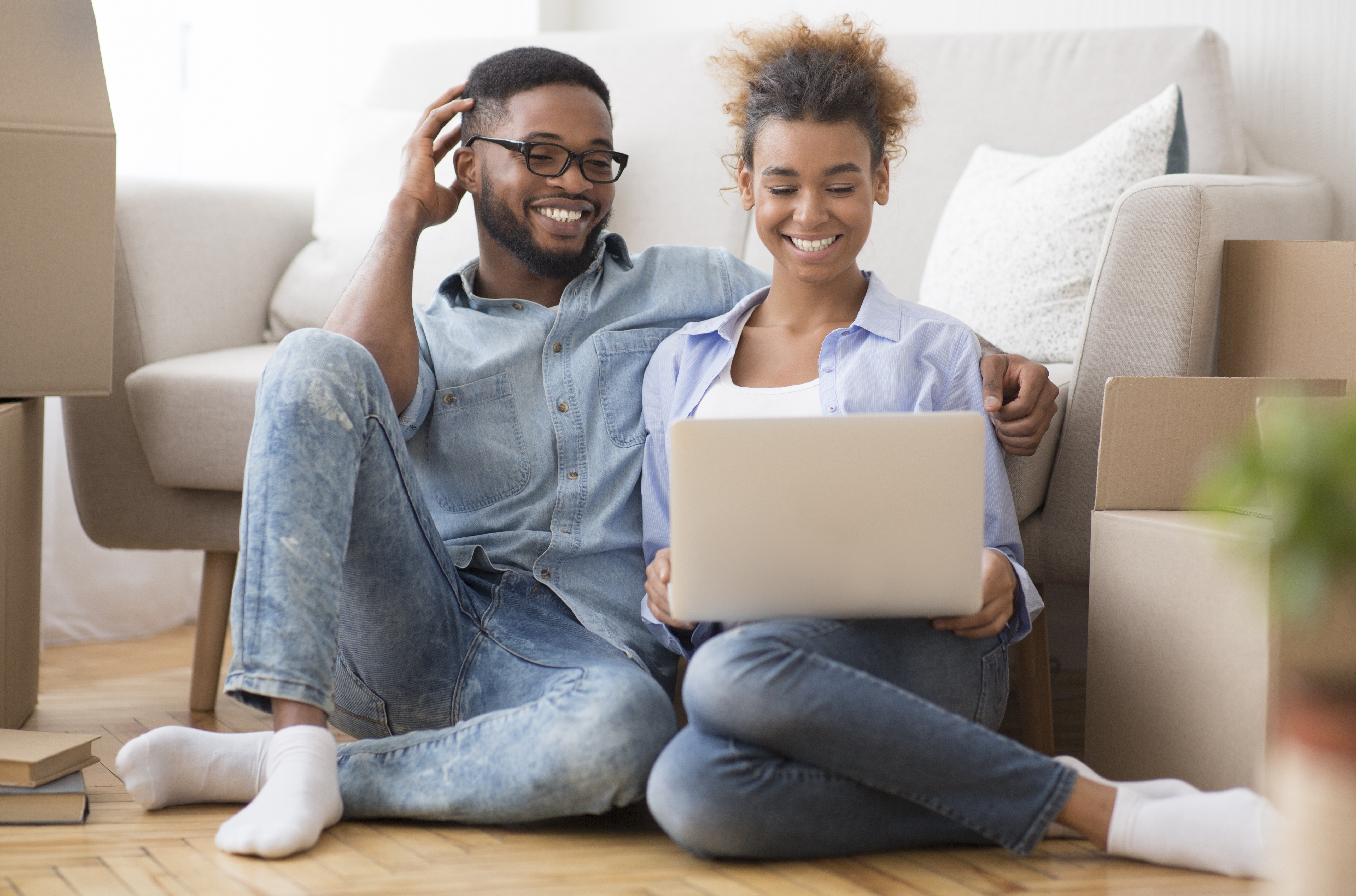 Couple sitting on floor on laptop computer Couple sitting on floor on laptop computer
