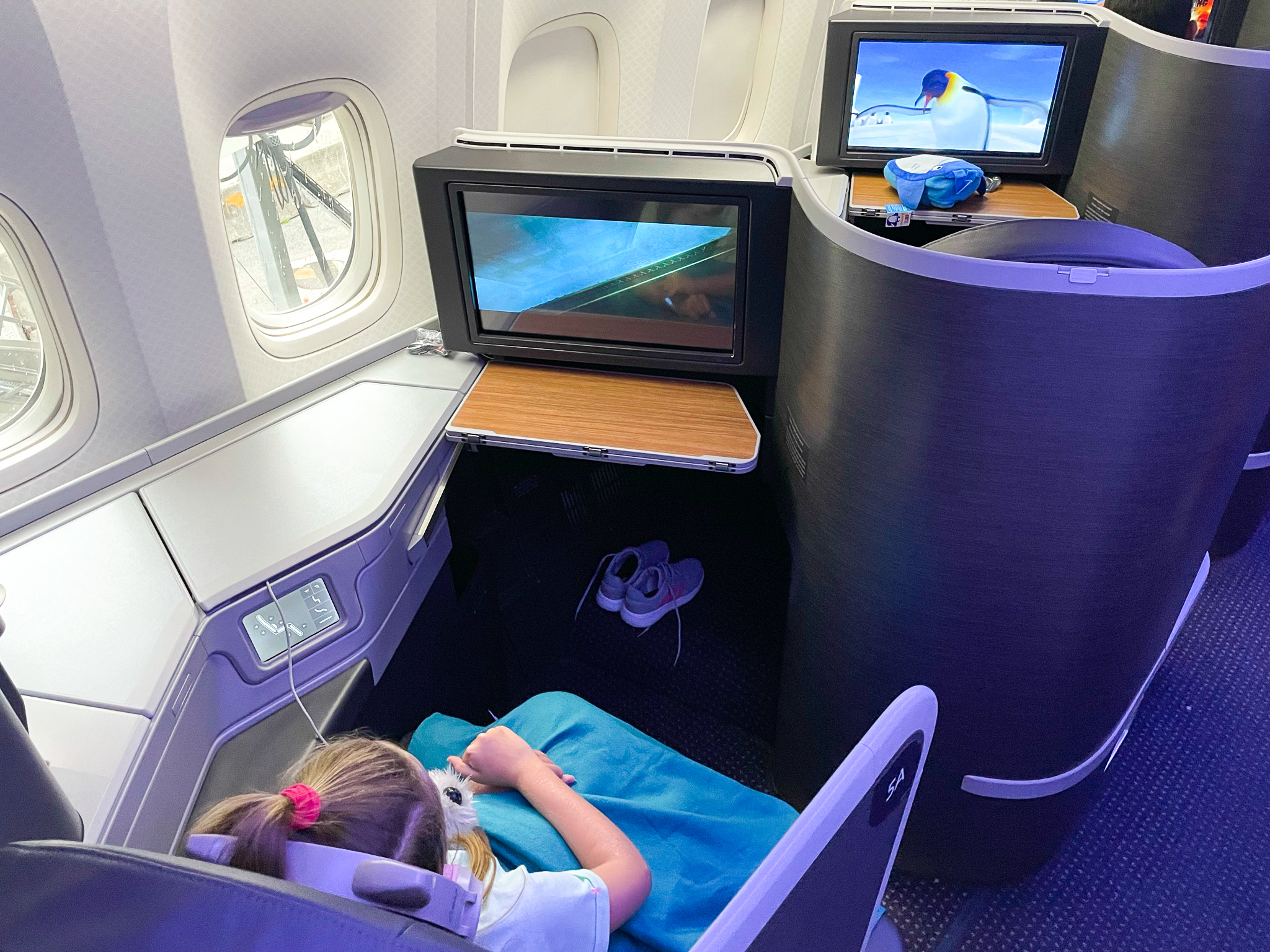 American Airlines First Flagship Business Class Miami to Boston girl watching a movie American Airlines First Flagship Business Class Miami to Boston girl watching a movie