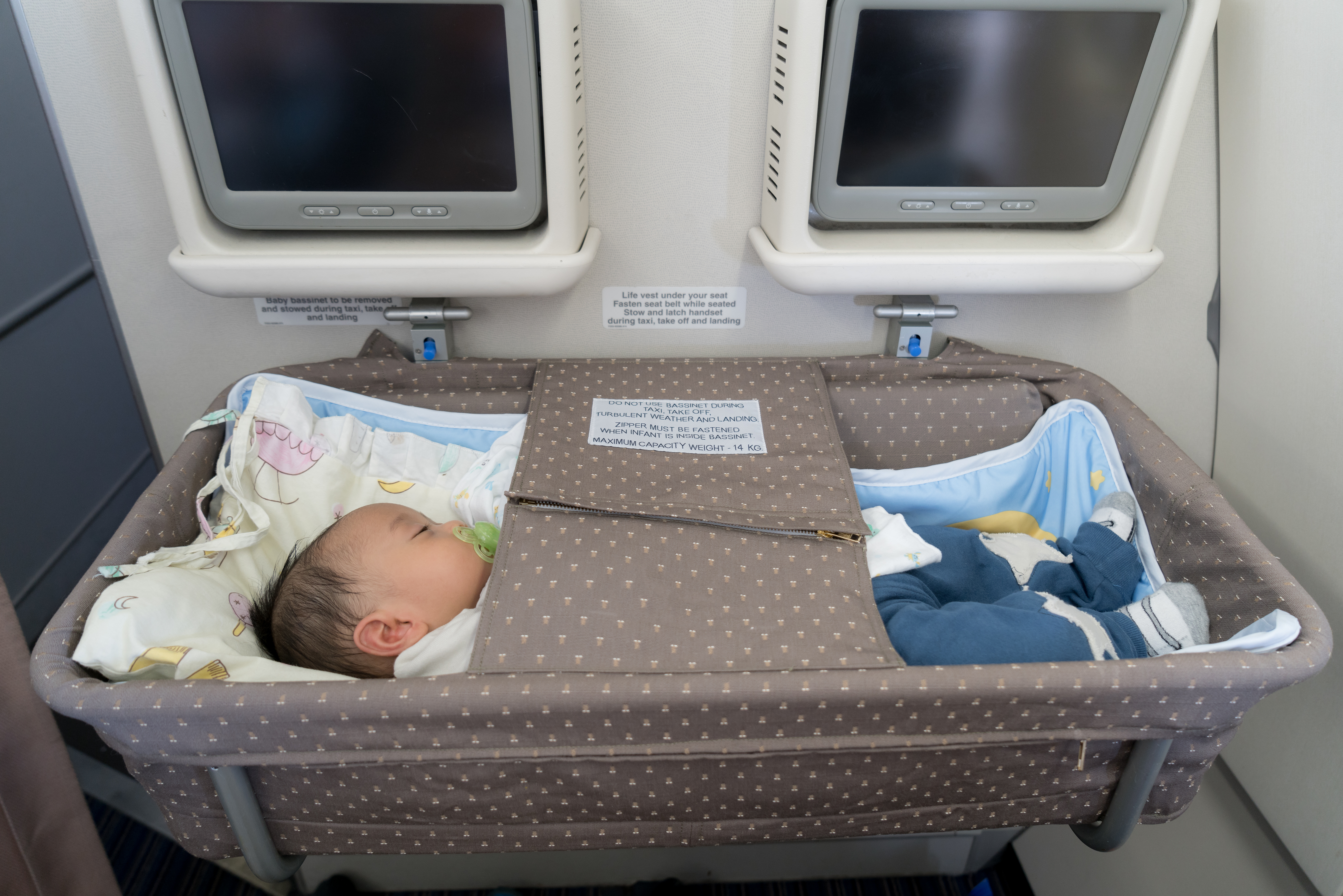 Baby in bassinet on airplane