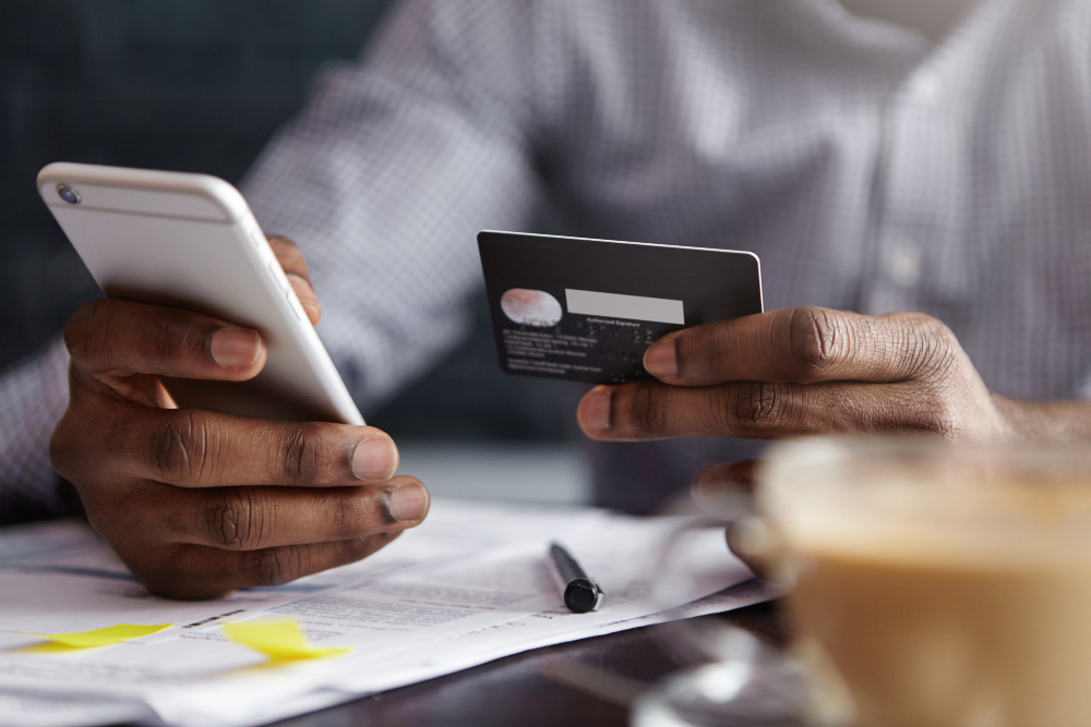 Man paying bill on cell phone with credit card
