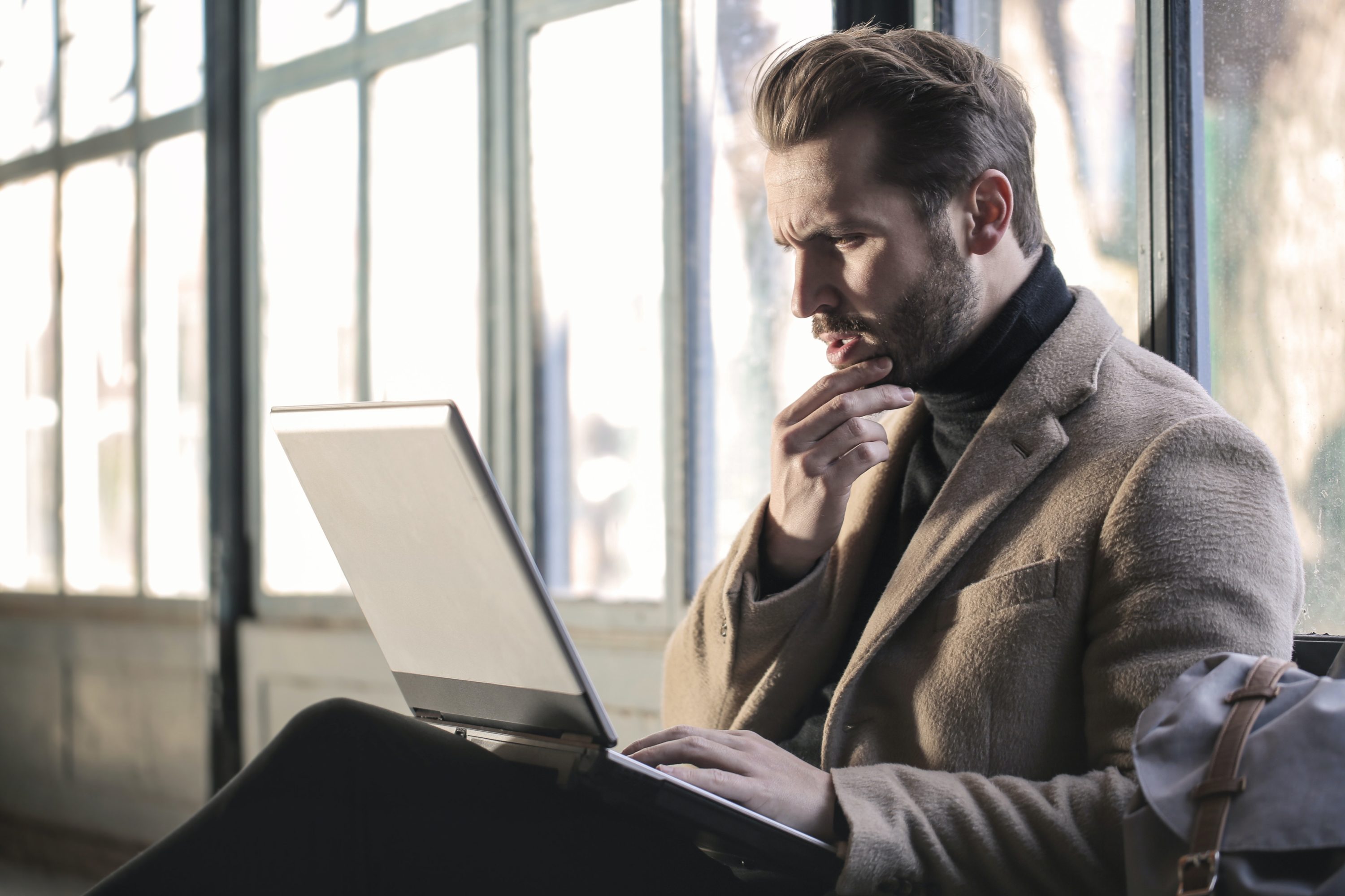 Confused man looking at laptop Confused man looking at laptop