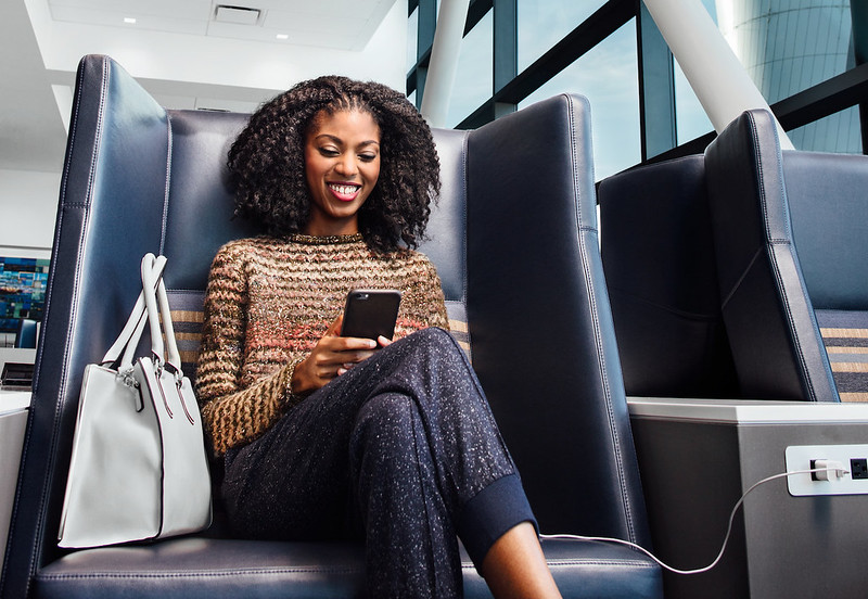 Delta Sky Club woman charging phone