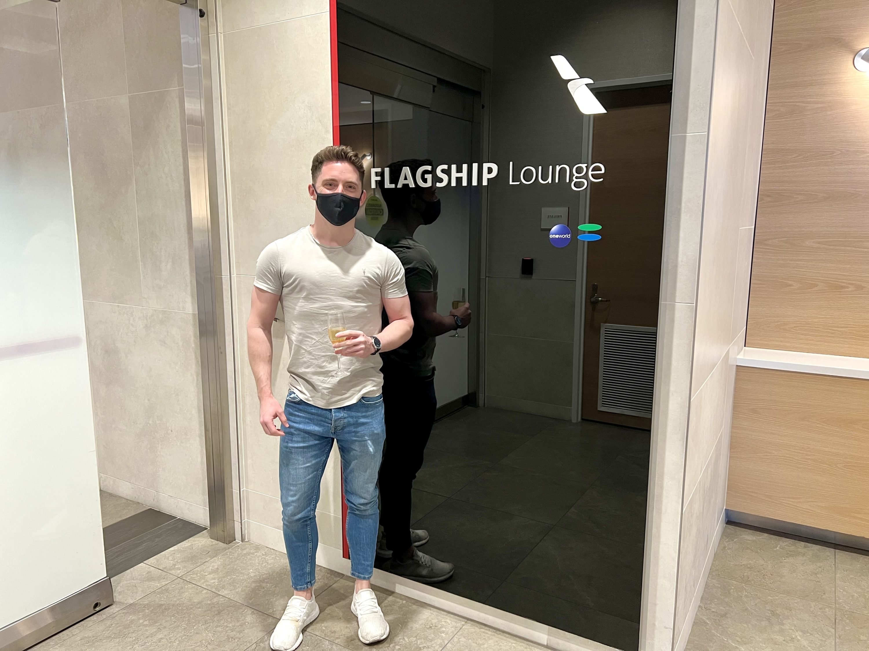 American Airlines Flagship First Flagship Lounge posing with Champagne