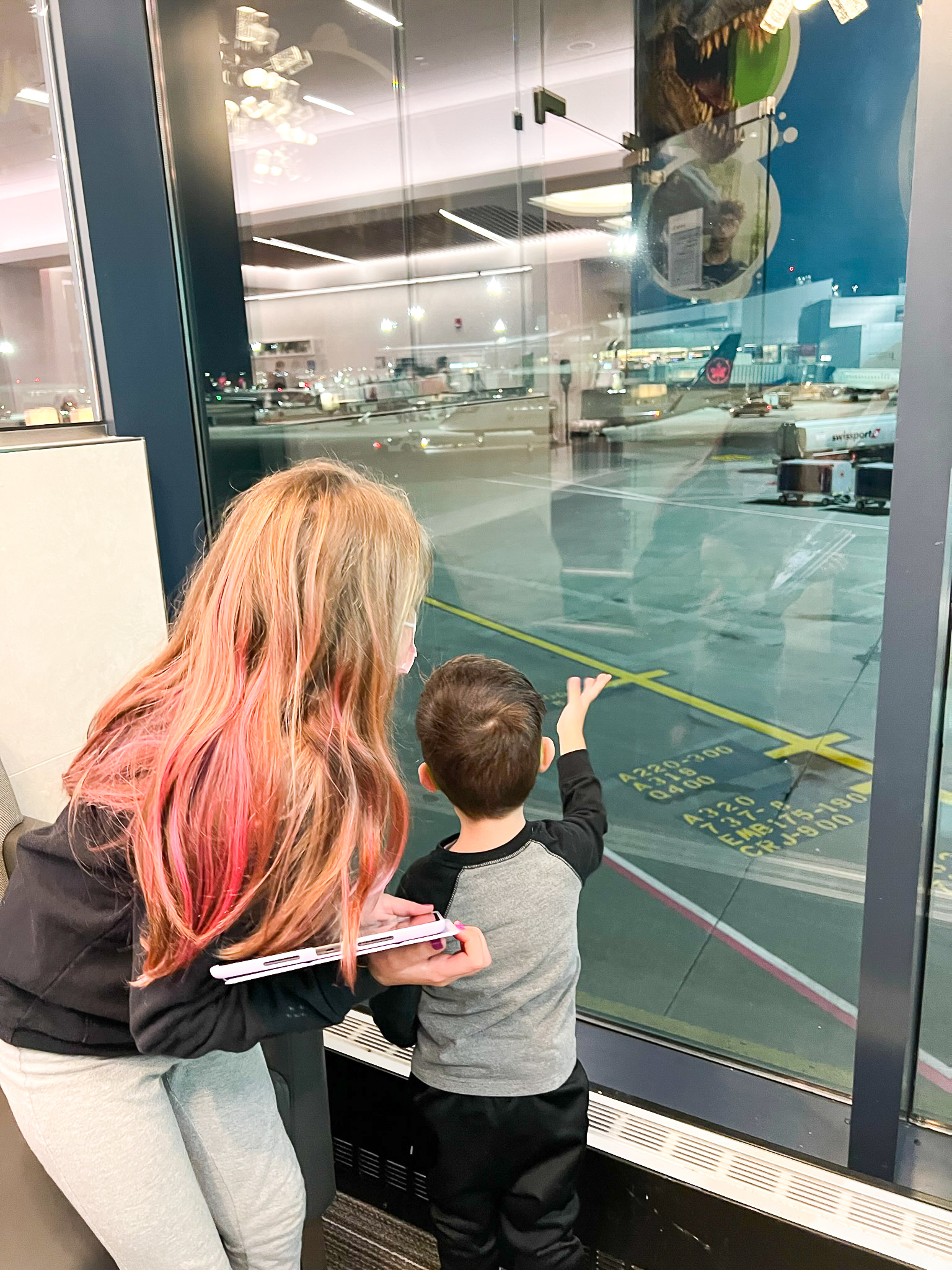 Kids looking at plane at the Admirals Club at Boston Logan International Airport