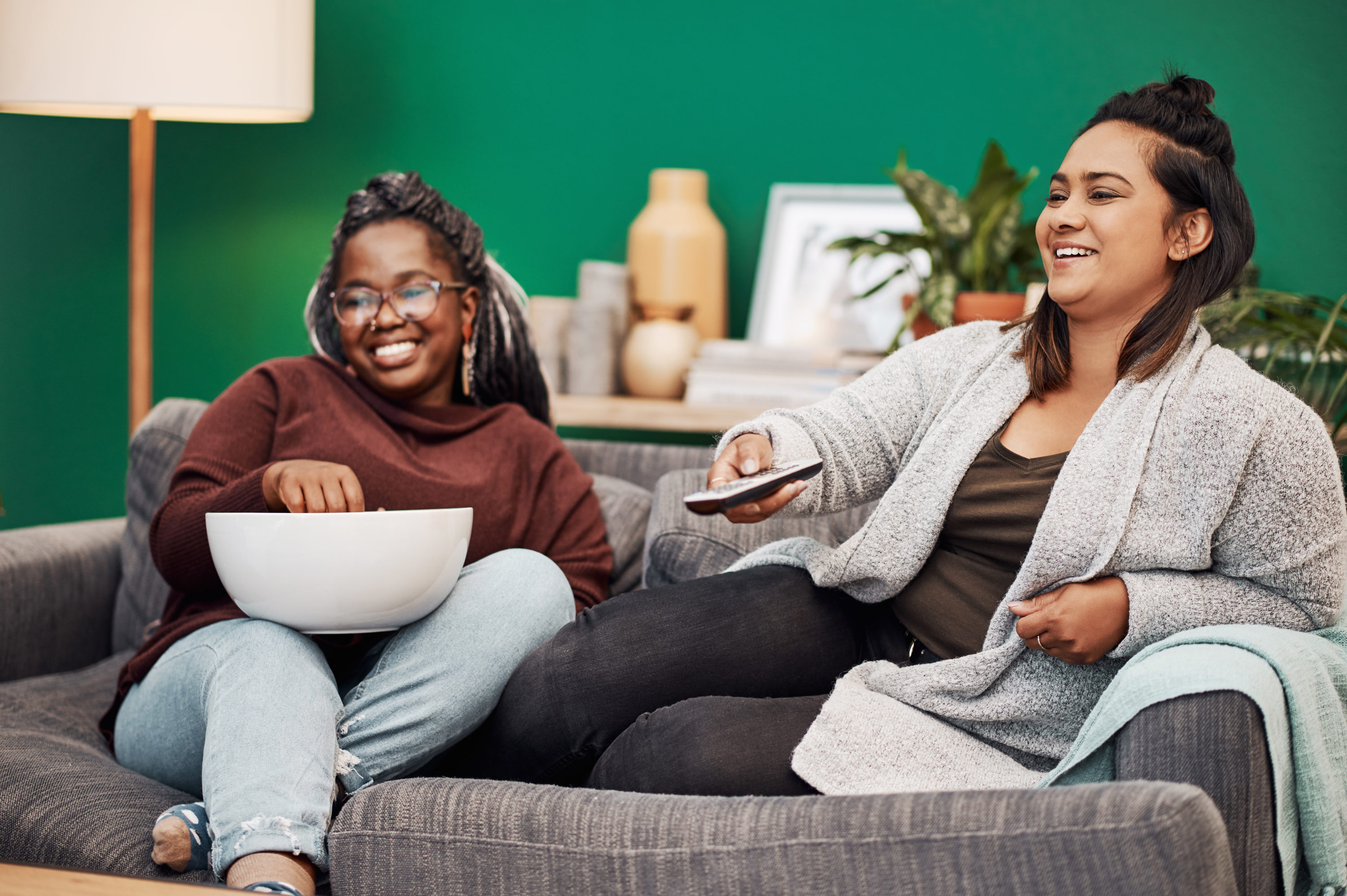 Two young women enjoying movie at home