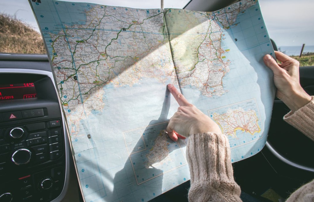 Lady in car pointing at map