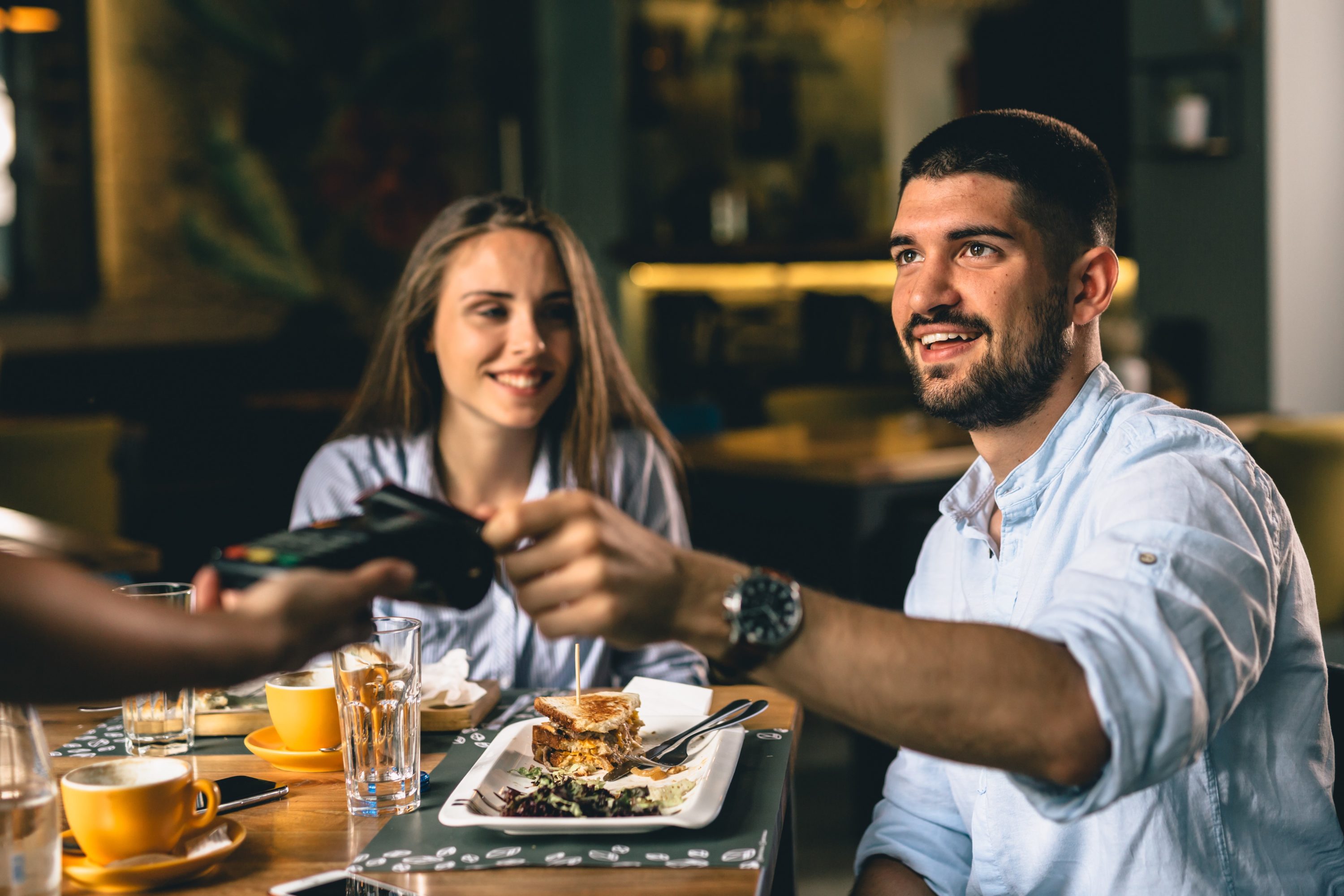 Man paying for meal in restaurant with credit card