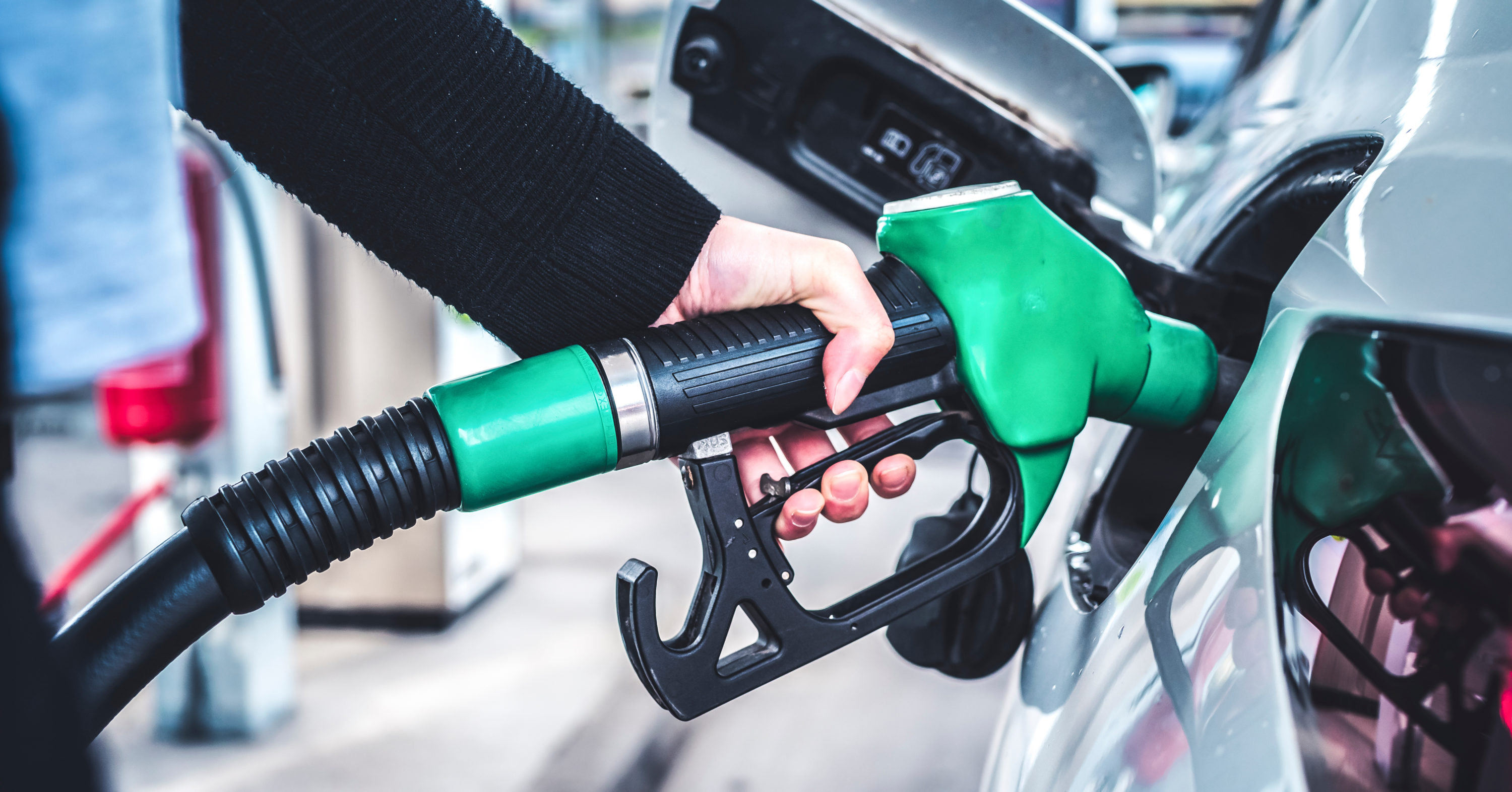 Person pumping gas green pump