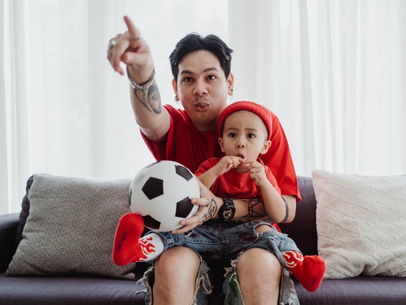 Young man and child watching TV