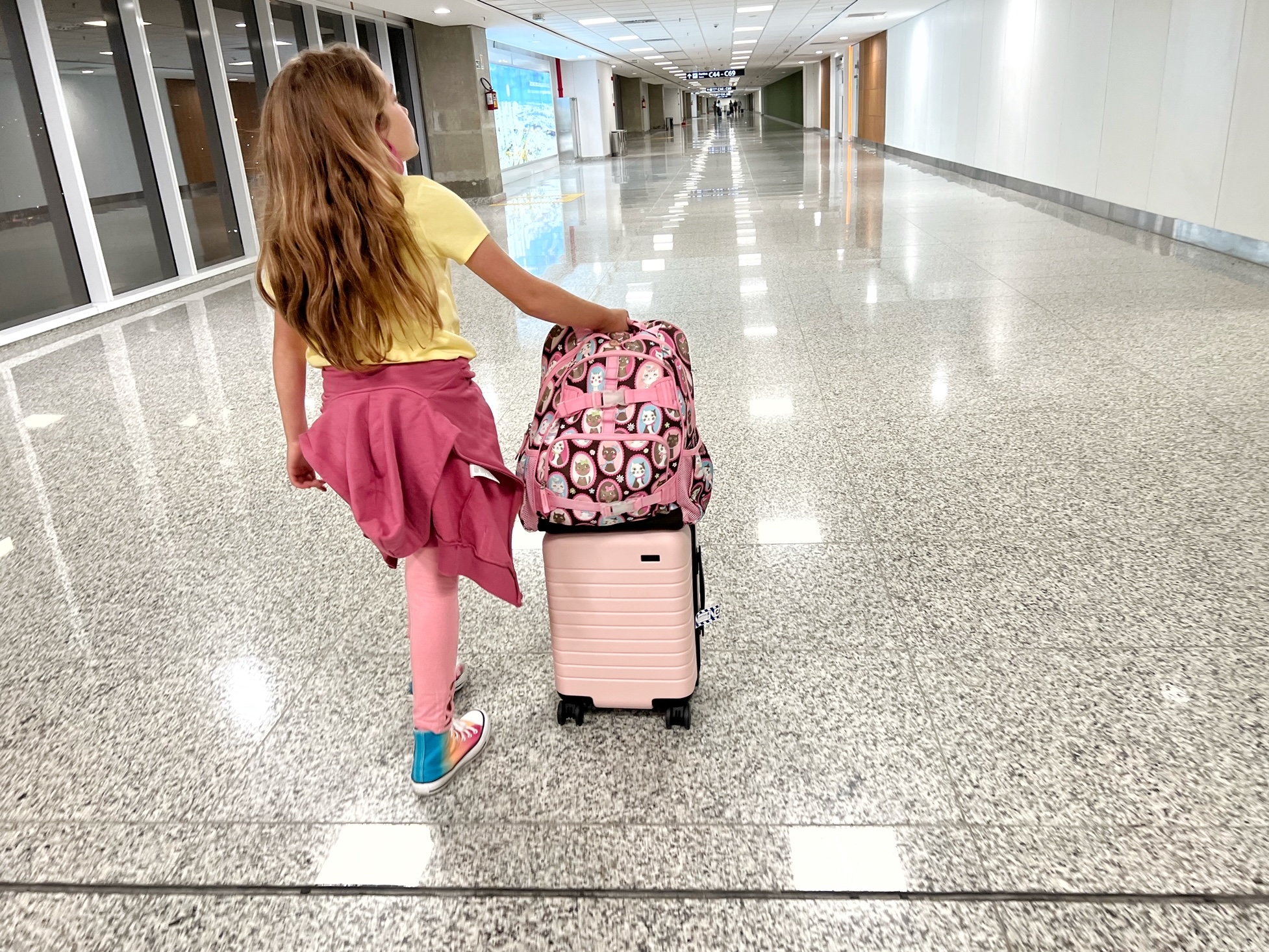 girl walking through airport with Away bag Girl walking through airport with Away bag in Rio de Janeiro airport GIG