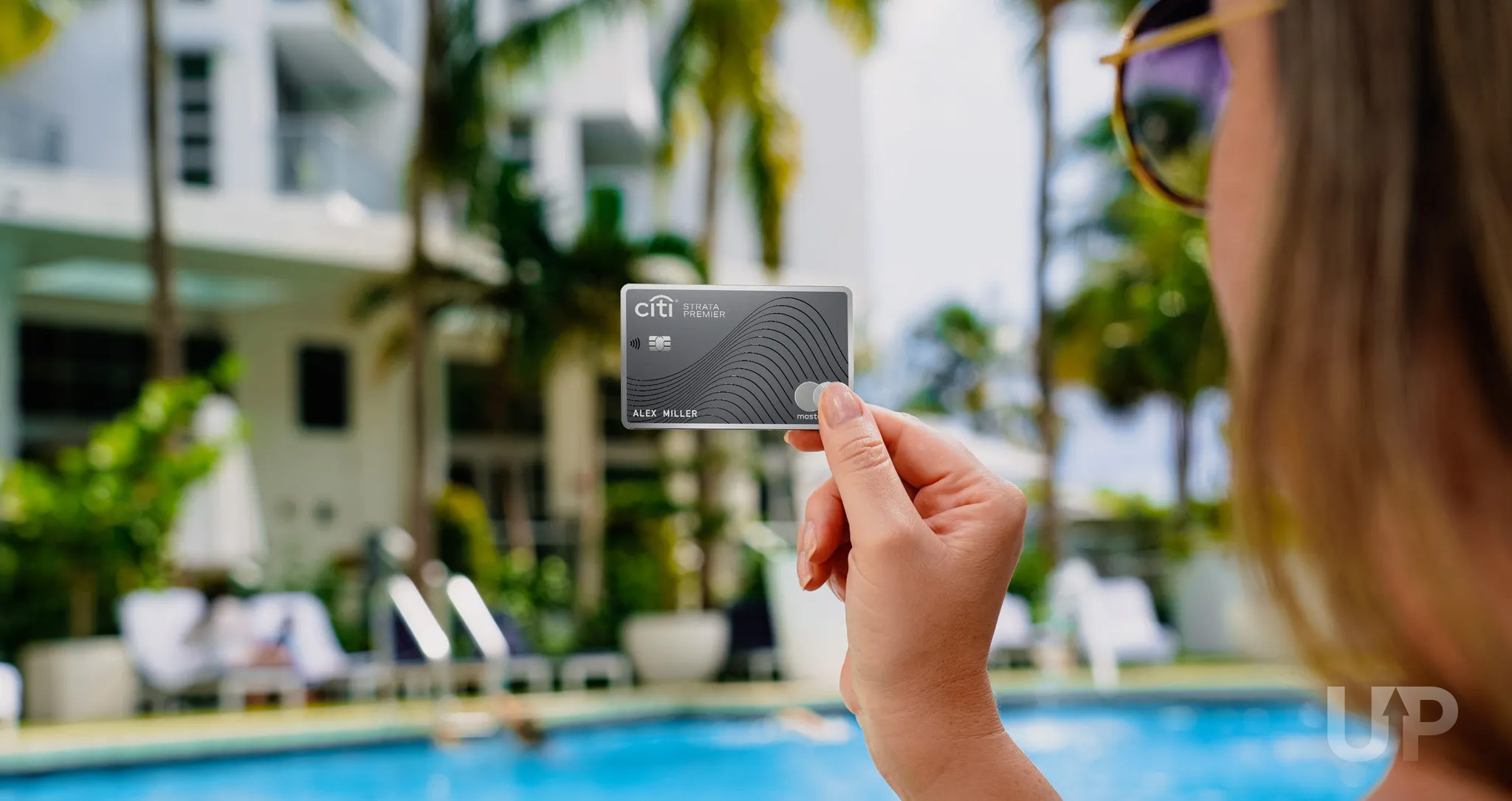 Citi Strata Premier Upgraded Points LLC 04 Large Citi Strata Premier card held near a pool