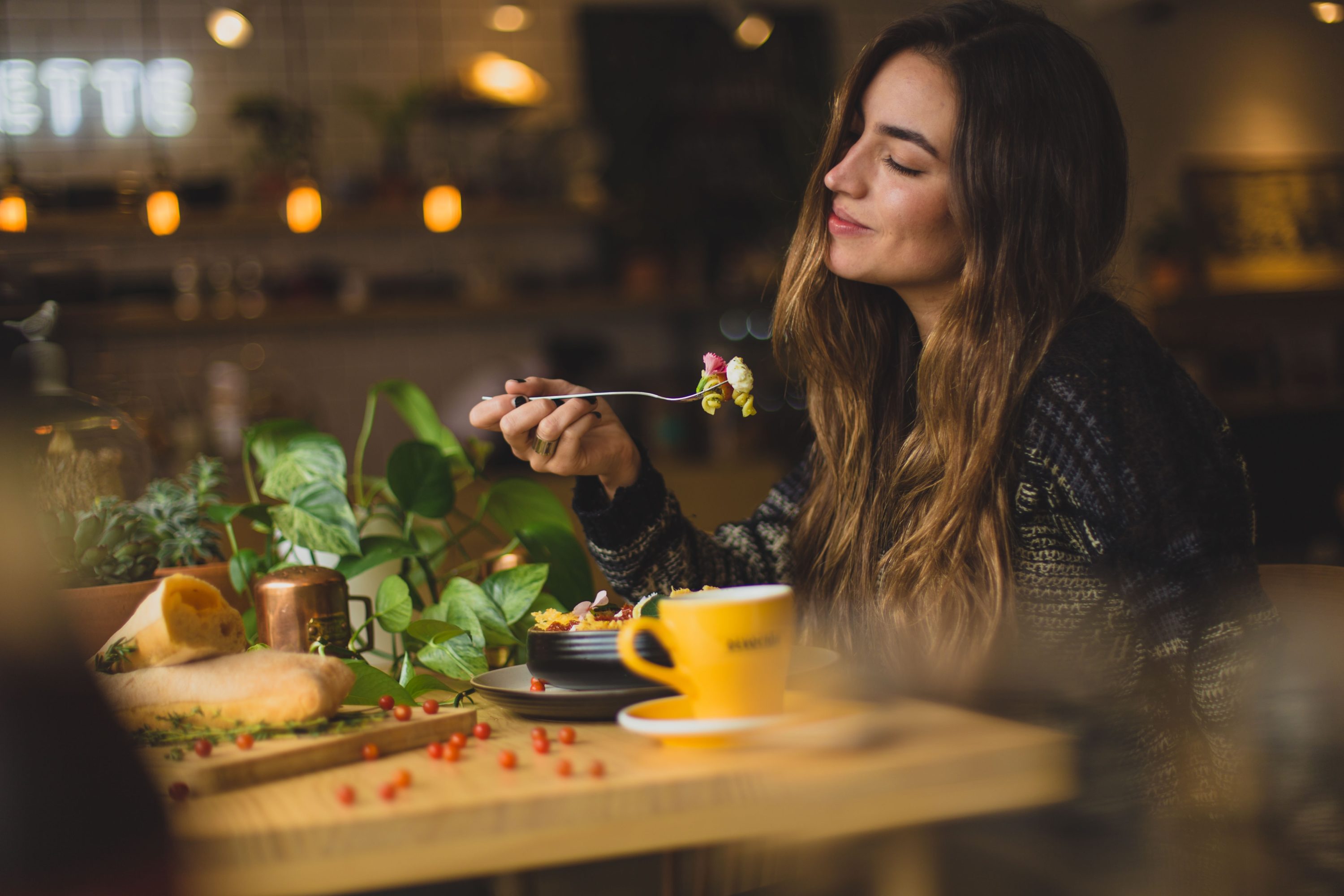 Woman enjoying meal while dining at restaurant