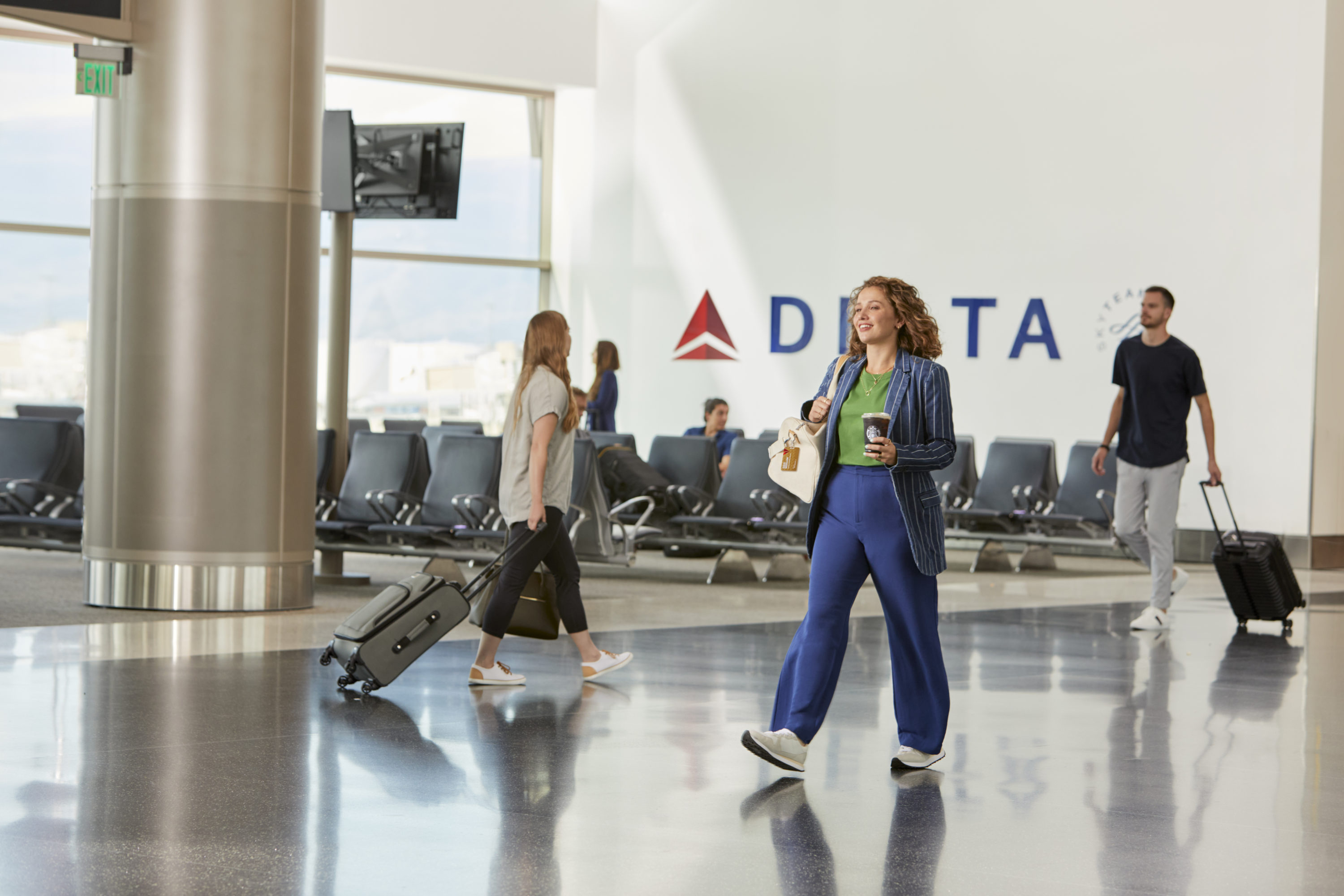 Woman walking with Starbucks at Delta terminal