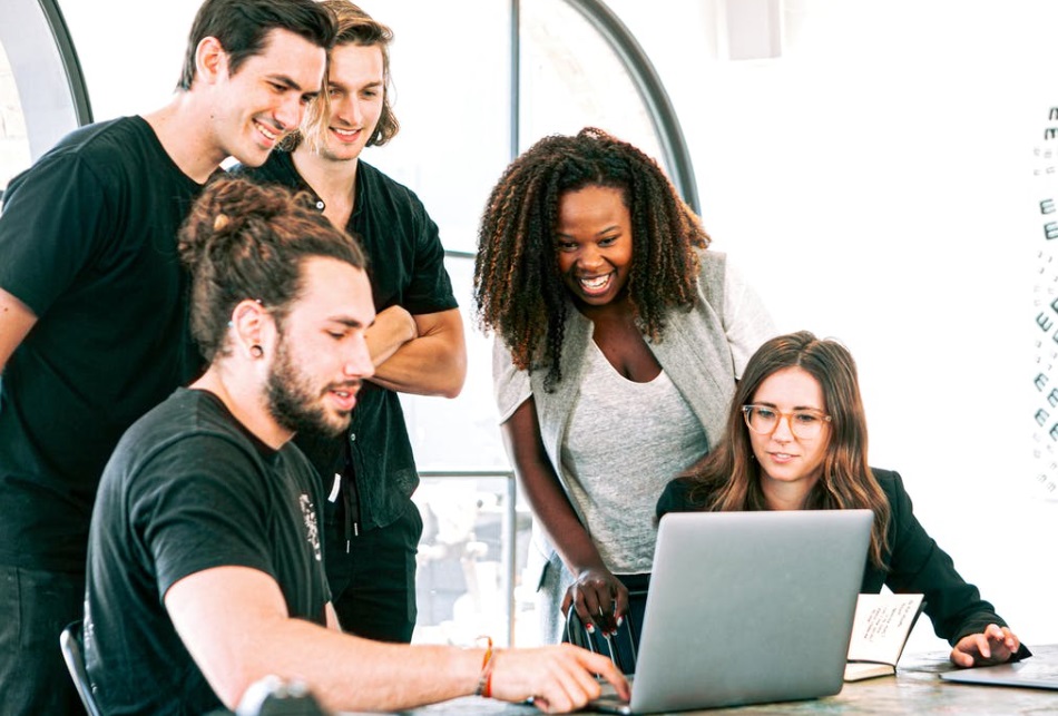 Work colleagues gathered around computer