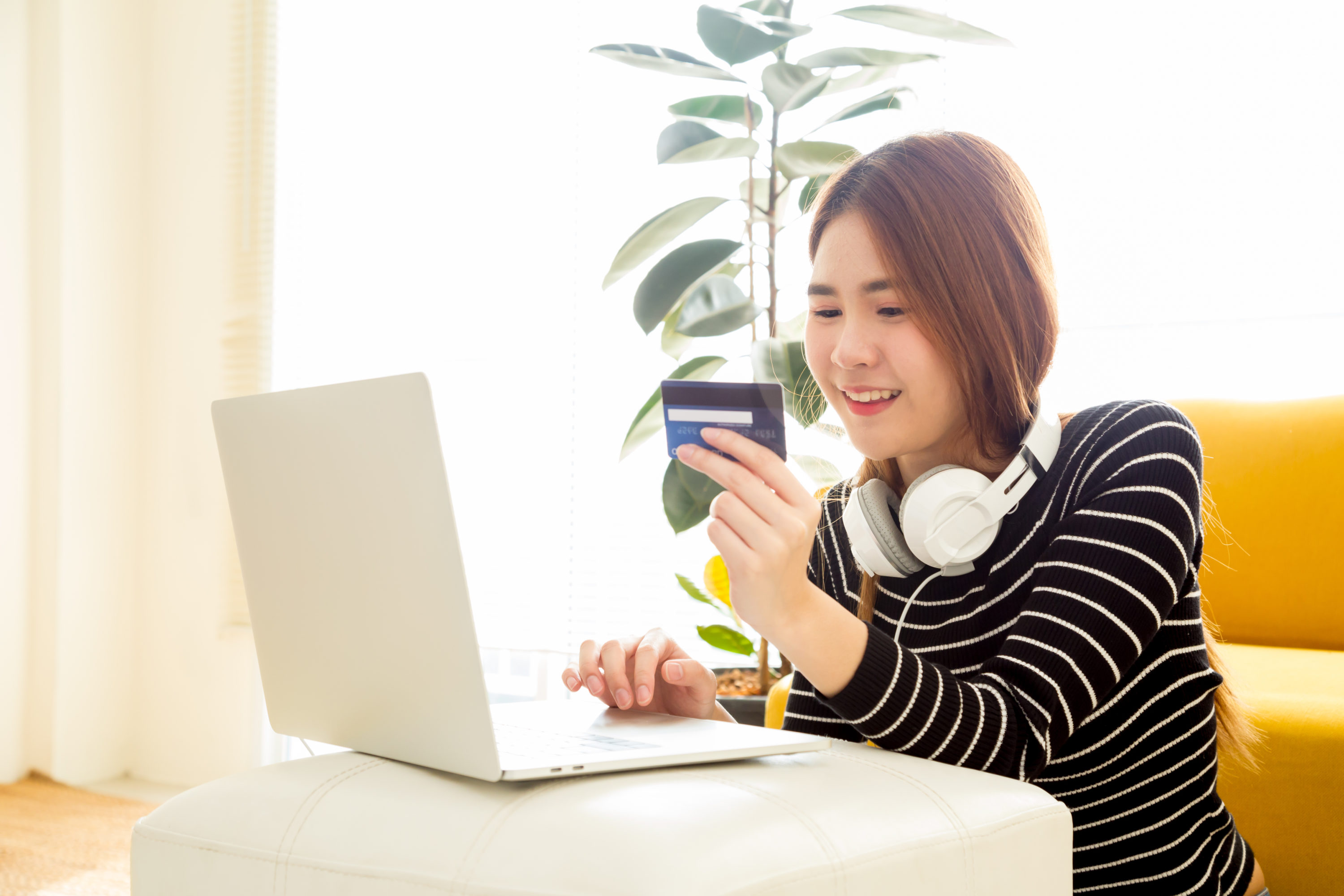 Young woman using credit card on laptop