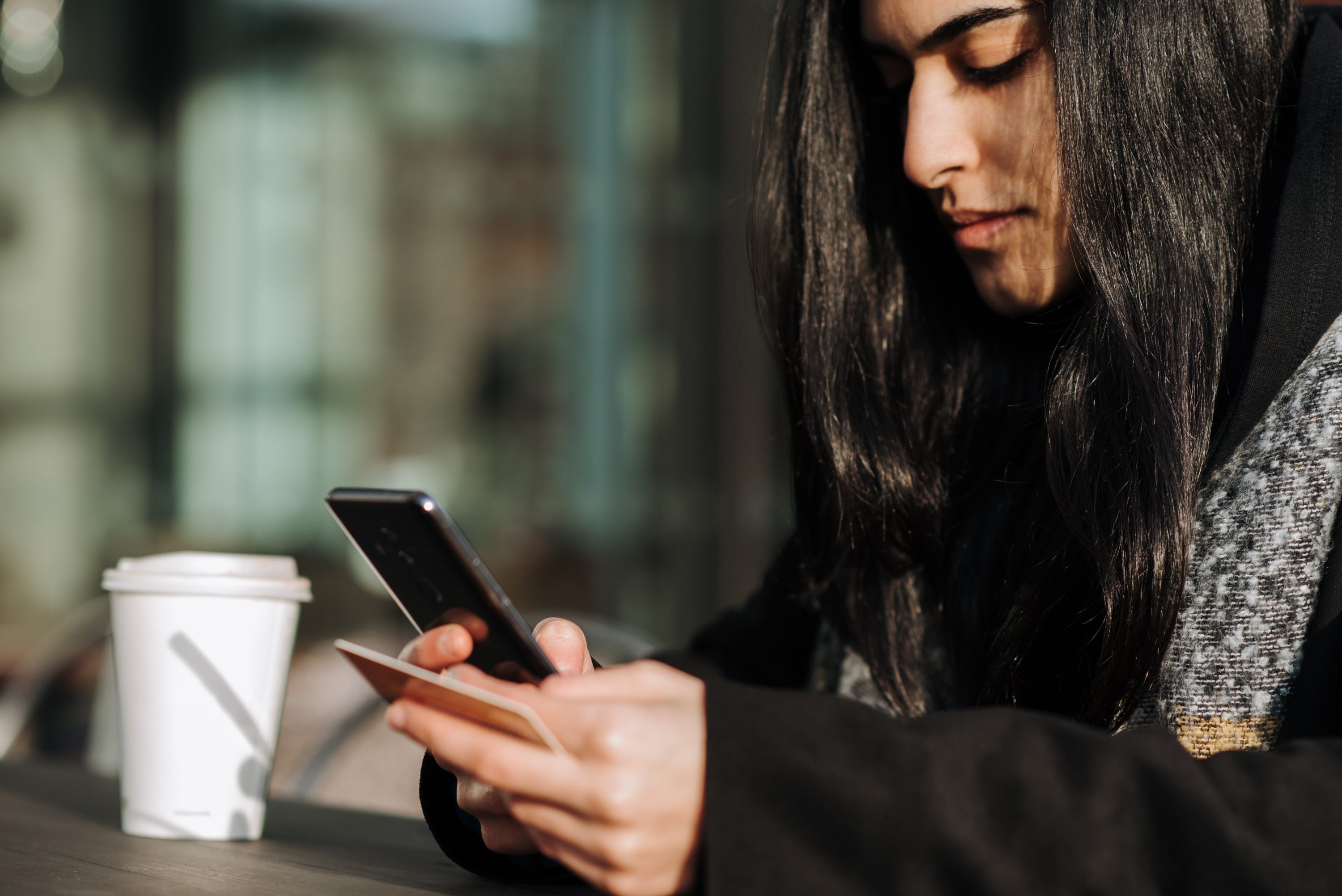 Woman comparing credit card APRs on her cell phone