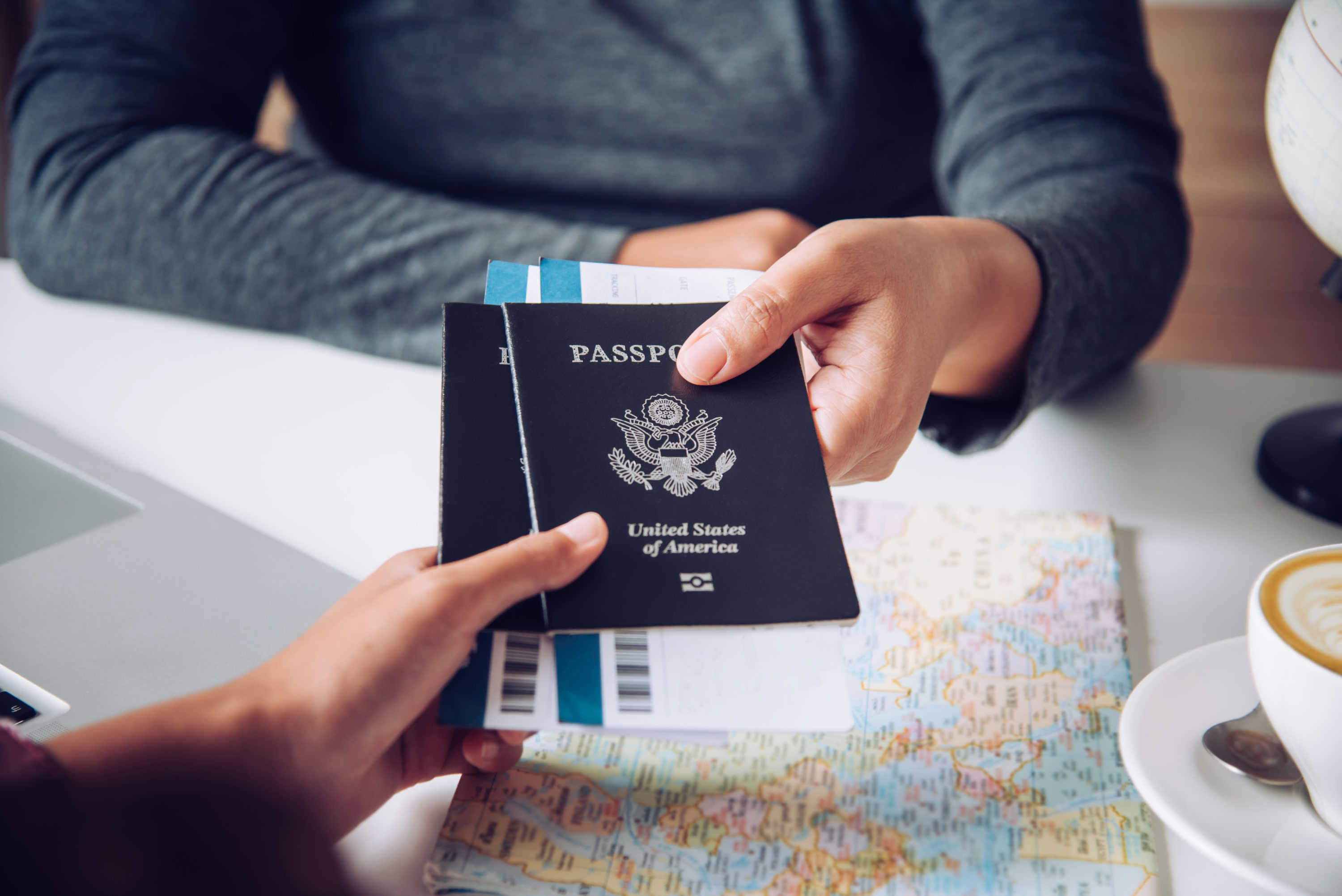 Person handing over 2 passports and tickets