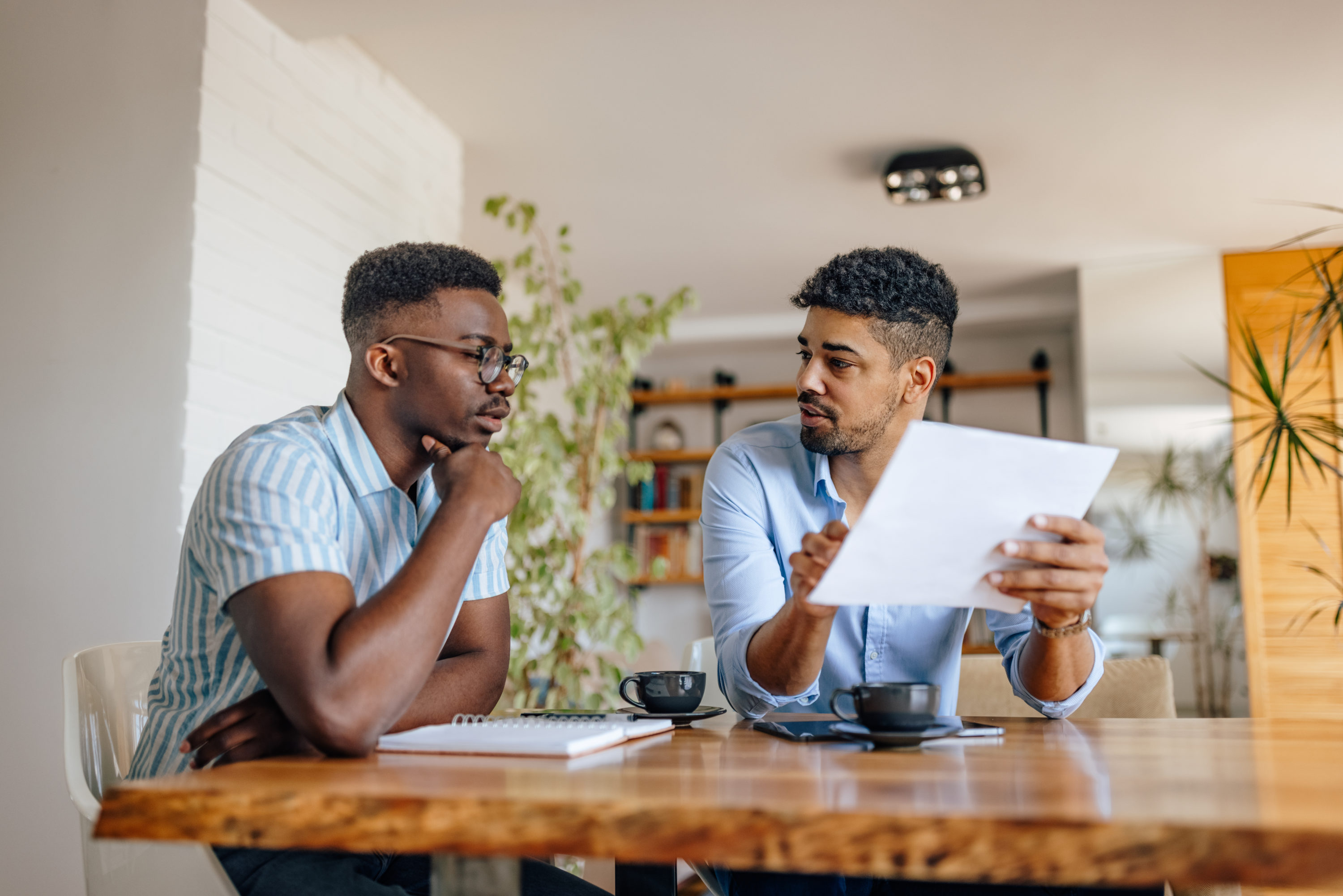Two men working on taxes over coffee