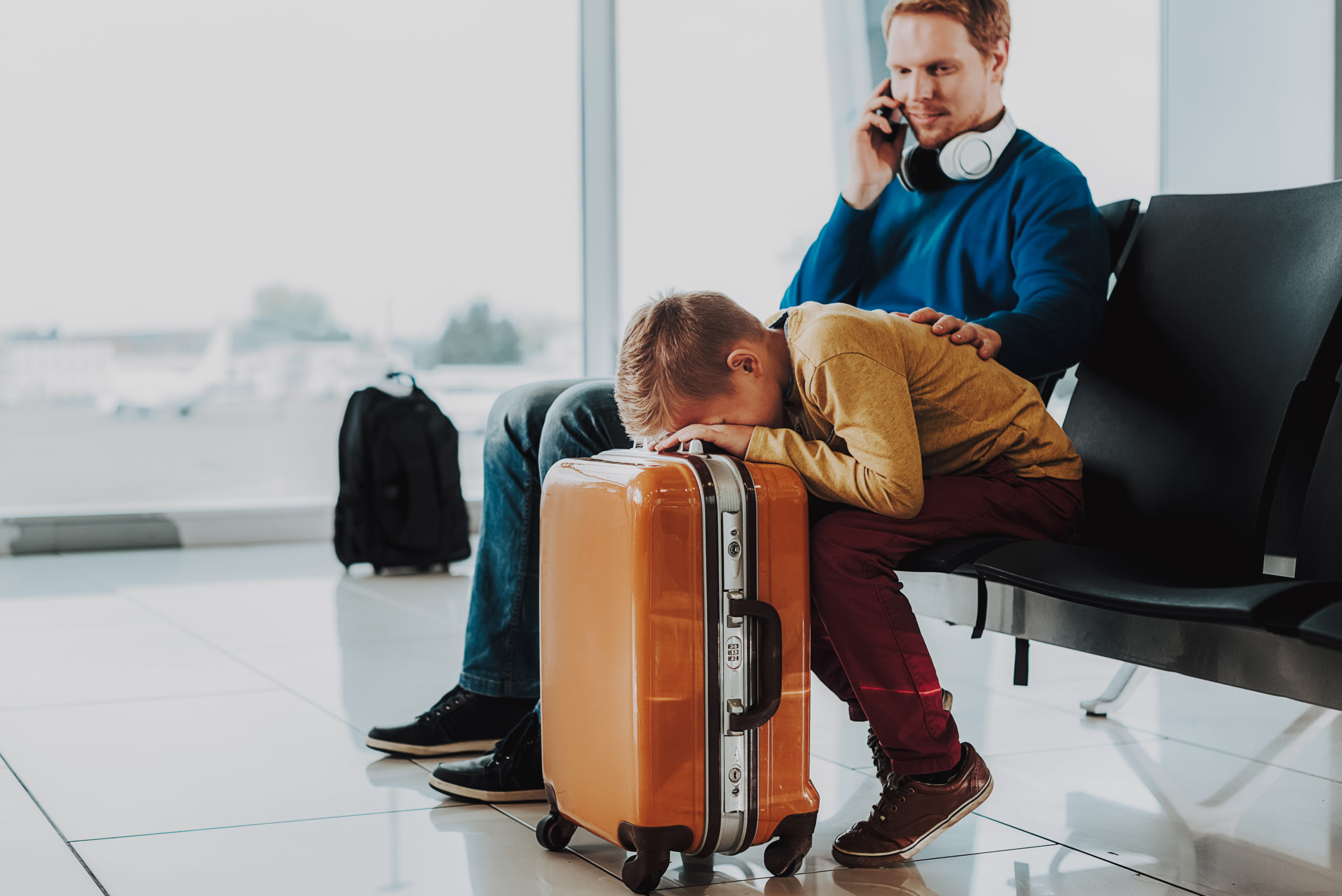 Father comforts son at airport