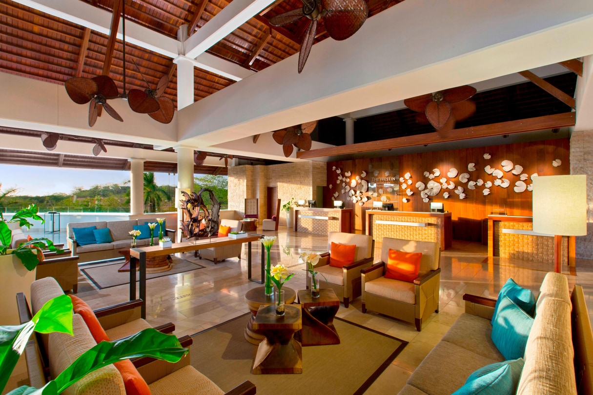 Photo of lobby, check-in counter, and seating area at the Westin Reserva Conchal All-Inclusive.