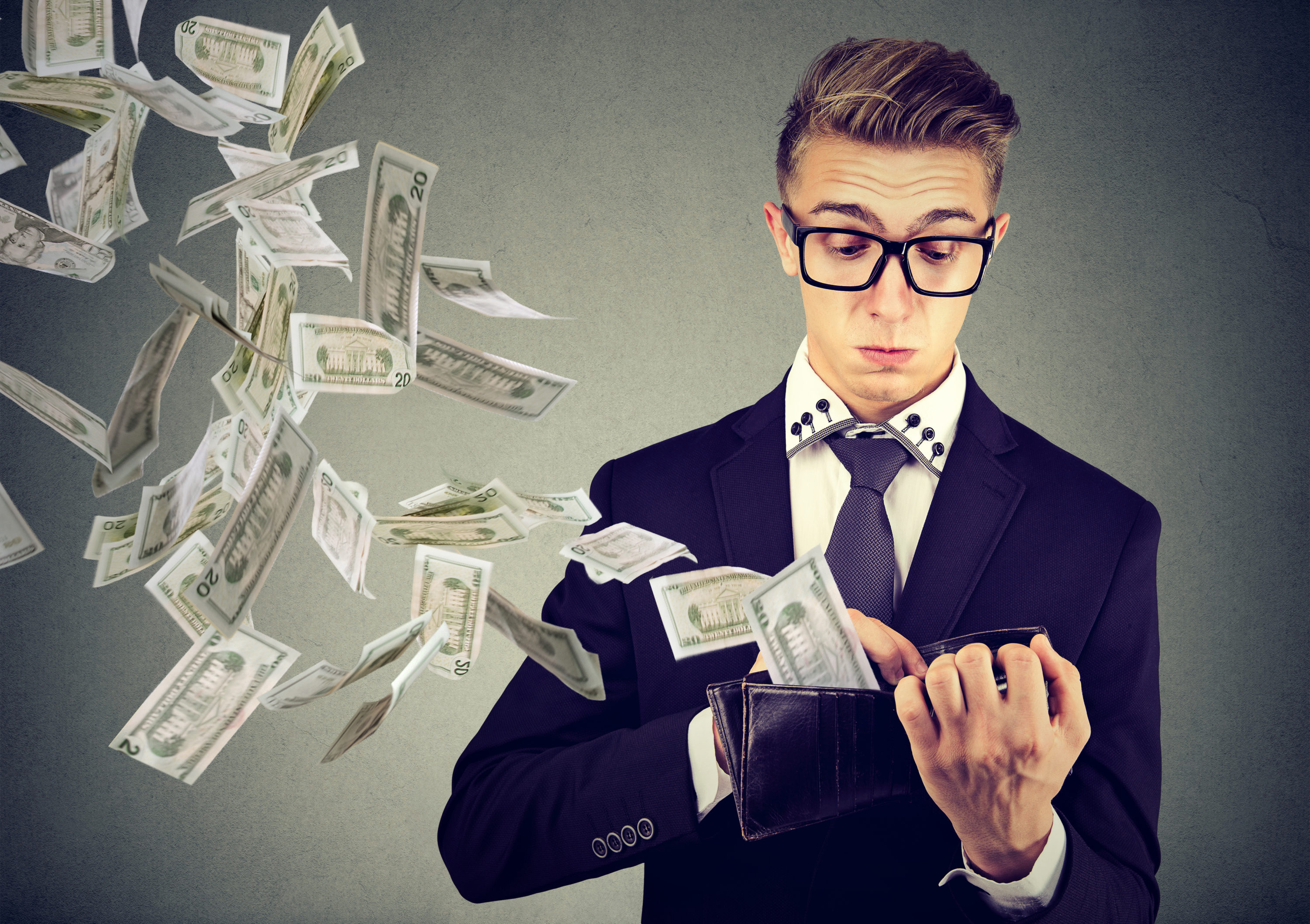 Money flying out of a man's wallet