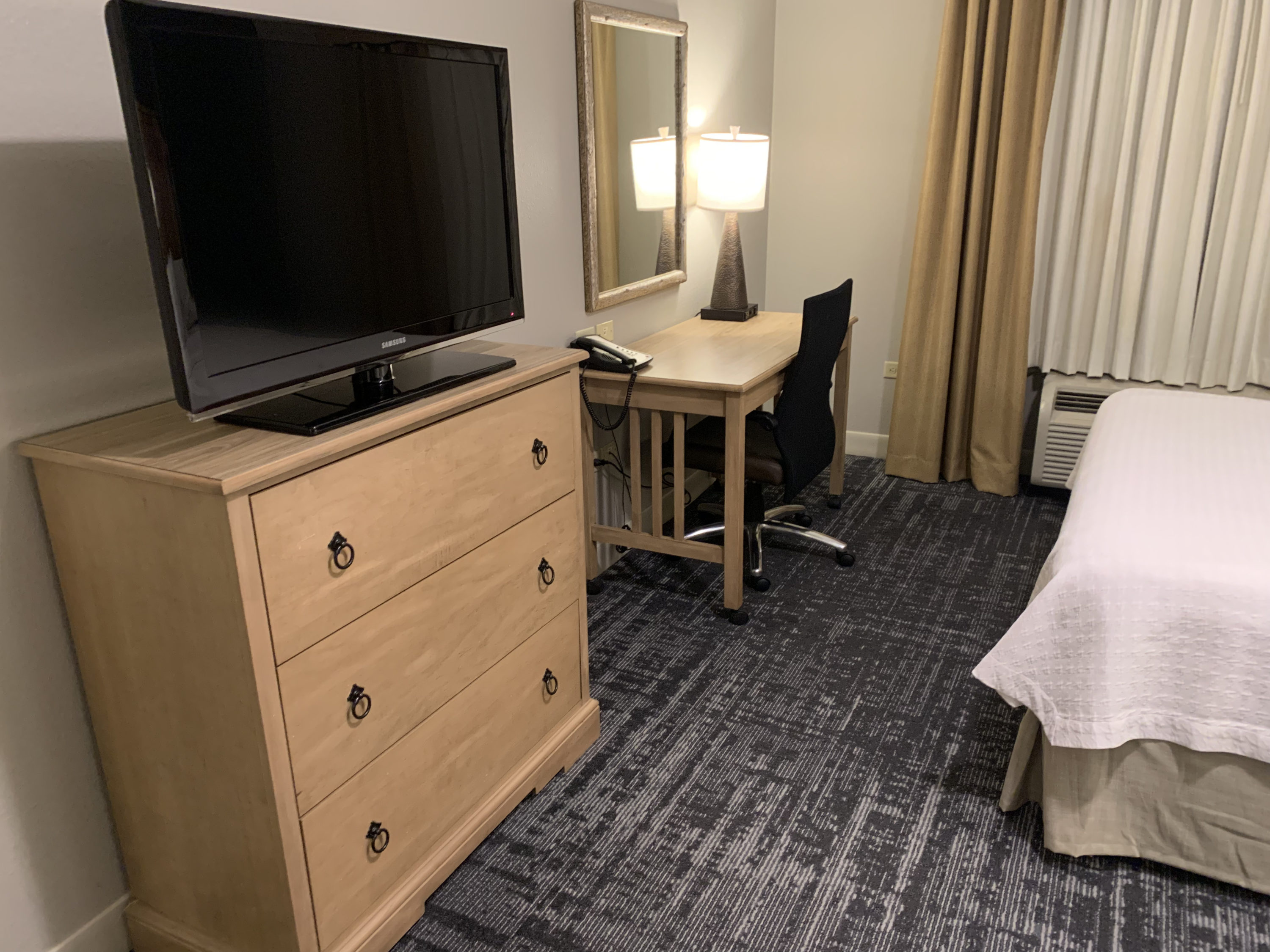 TV dresser and desk in the guestroom bedroom at Homewood Suites Austin Round Rock