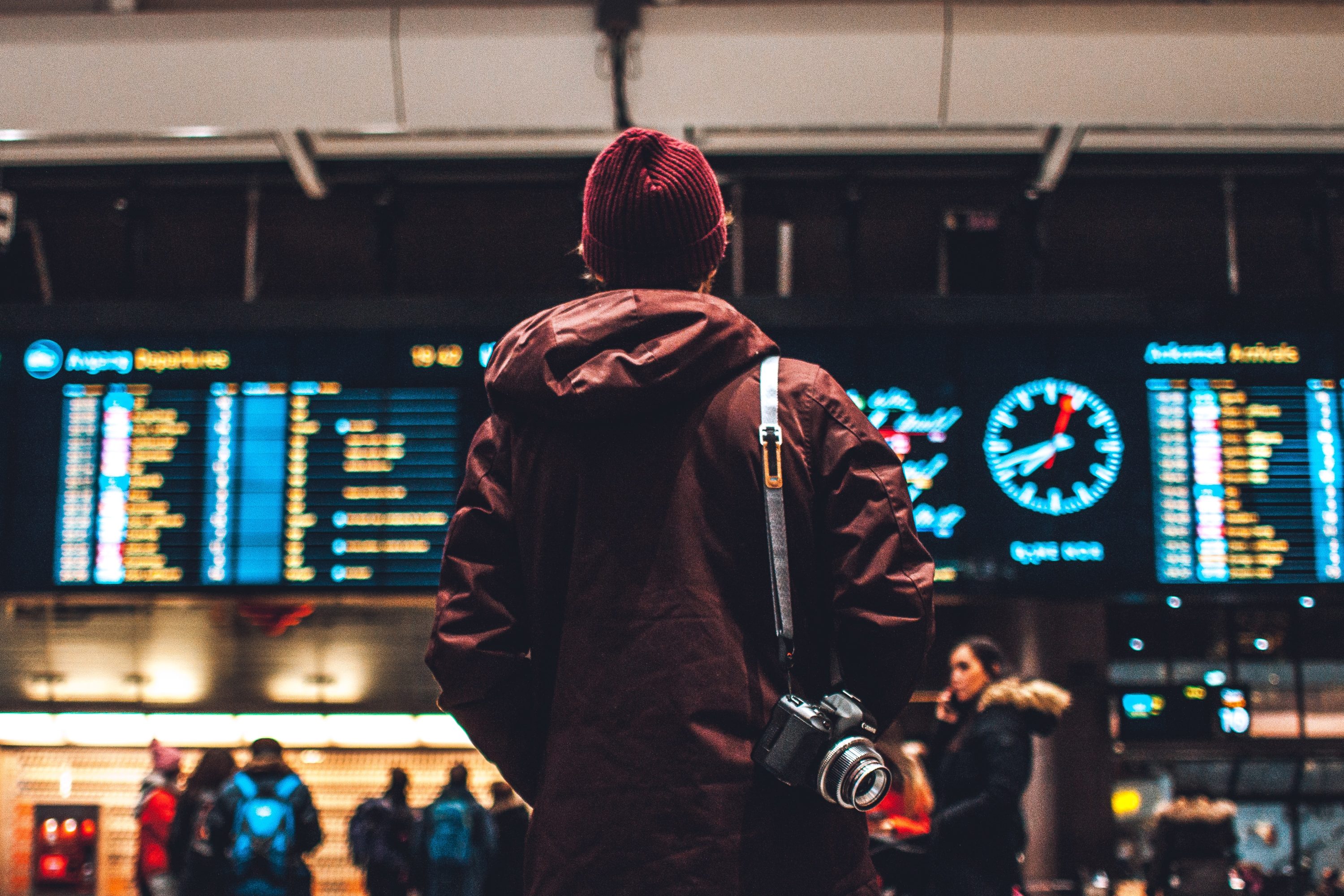 Man looking at departure board at airport Man looking at departure board at airport