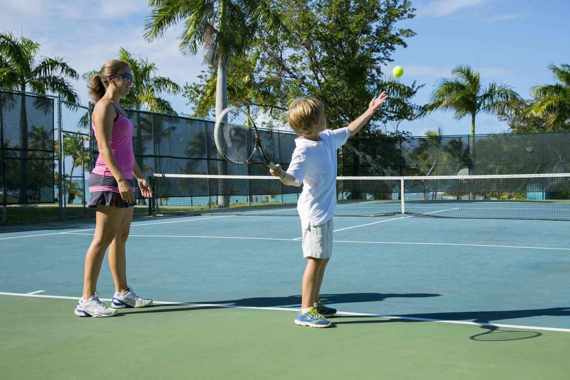 A mom and son play tennis at The Buccaneer Beach and Golf Resort. A mom and son play tennis at The Buccaneer Beach and Golf Resort.