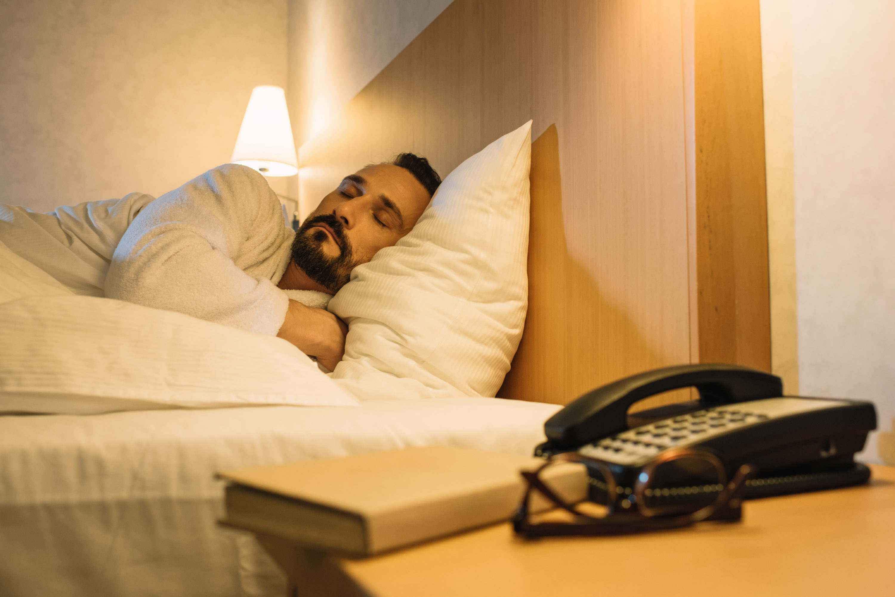 Man in bathrobe sleeping in hotel room Man in bathrobe sleeping in hotel room