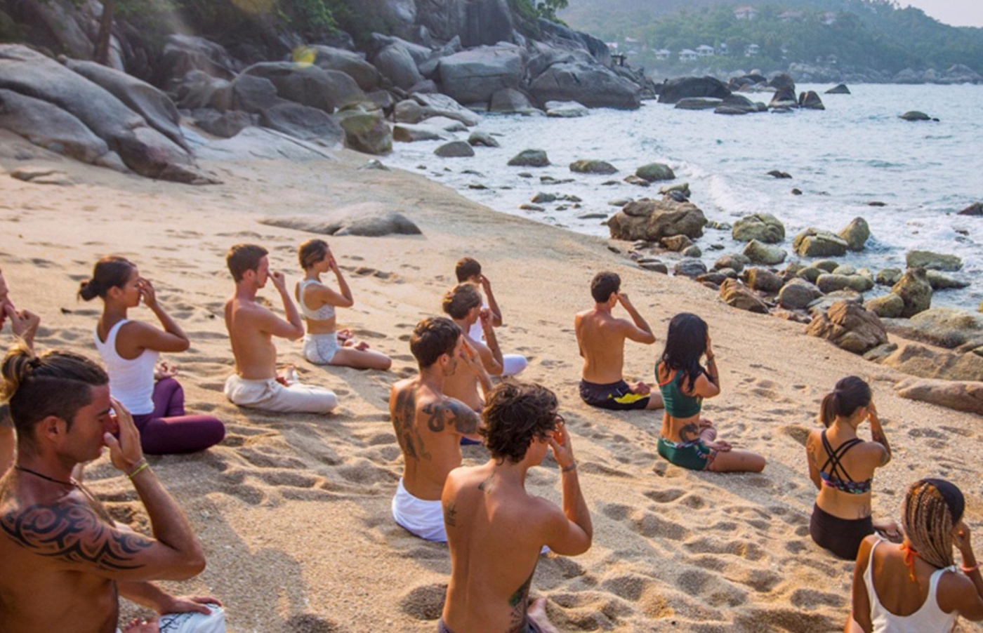 Vikasa Samui A group of people doing yoga on a beautiful beach