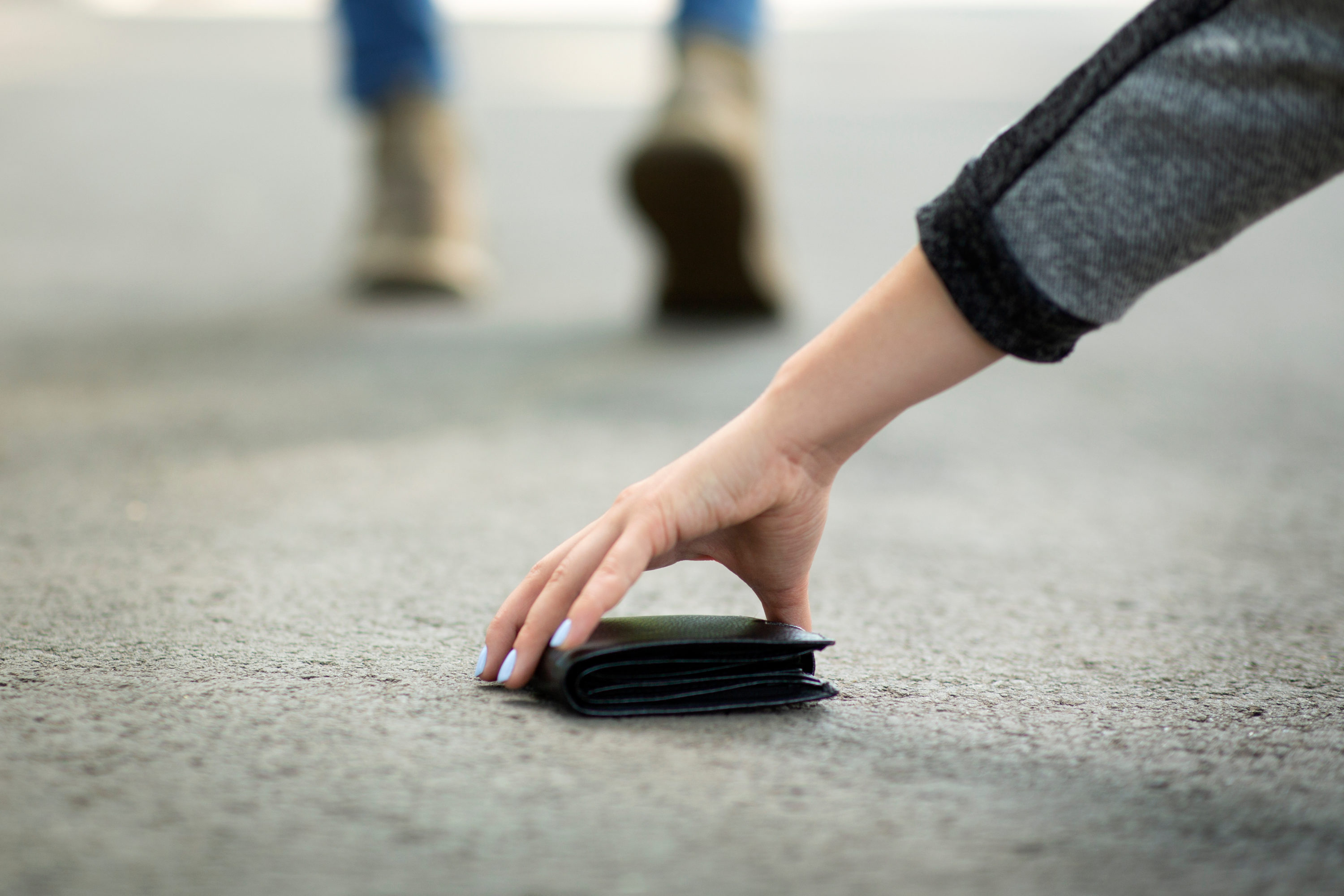Woman picking up dropped wallet Woman picking up dropped wallet