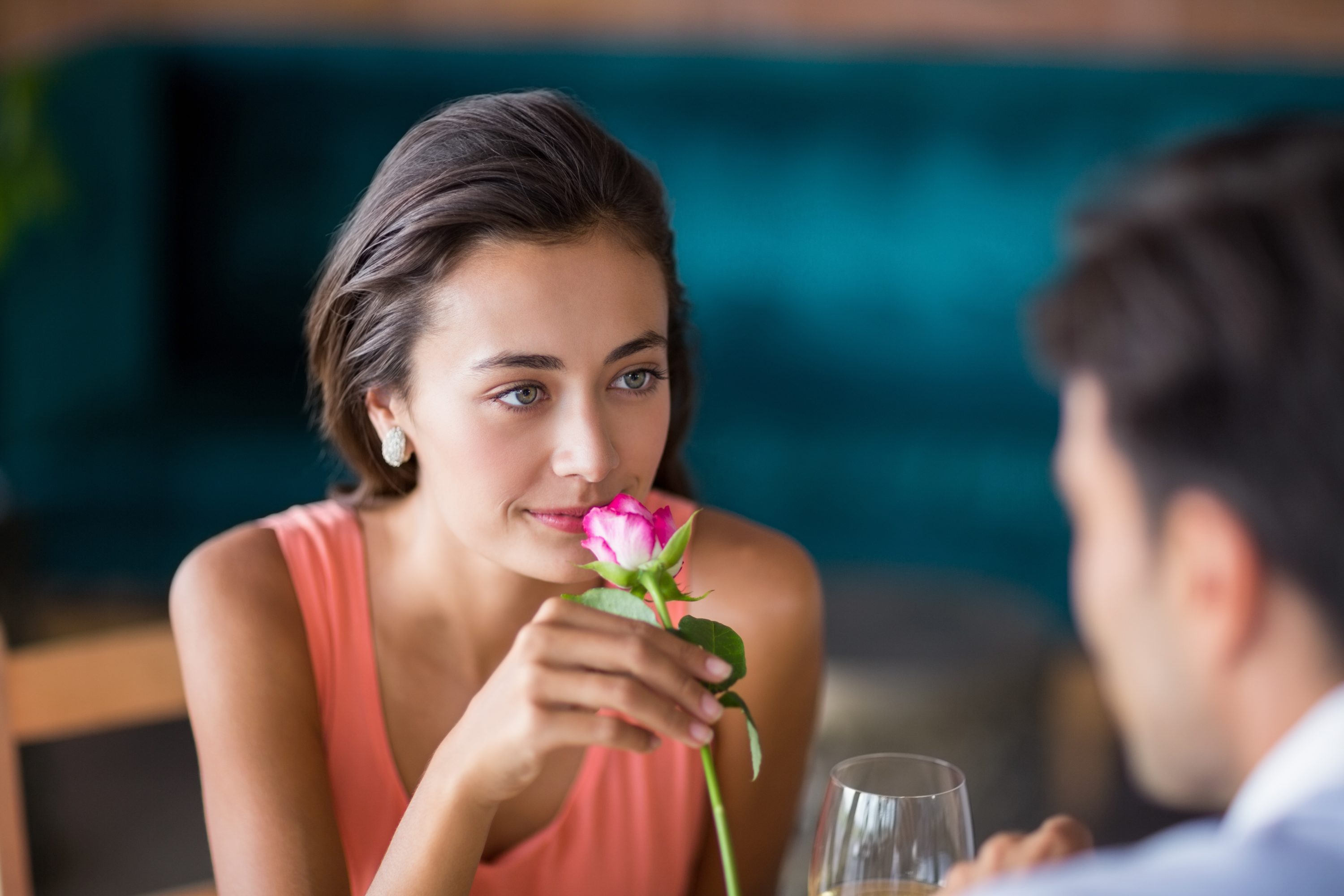 Woman smelling a rose offered by man Woman smelling a rose offered by man