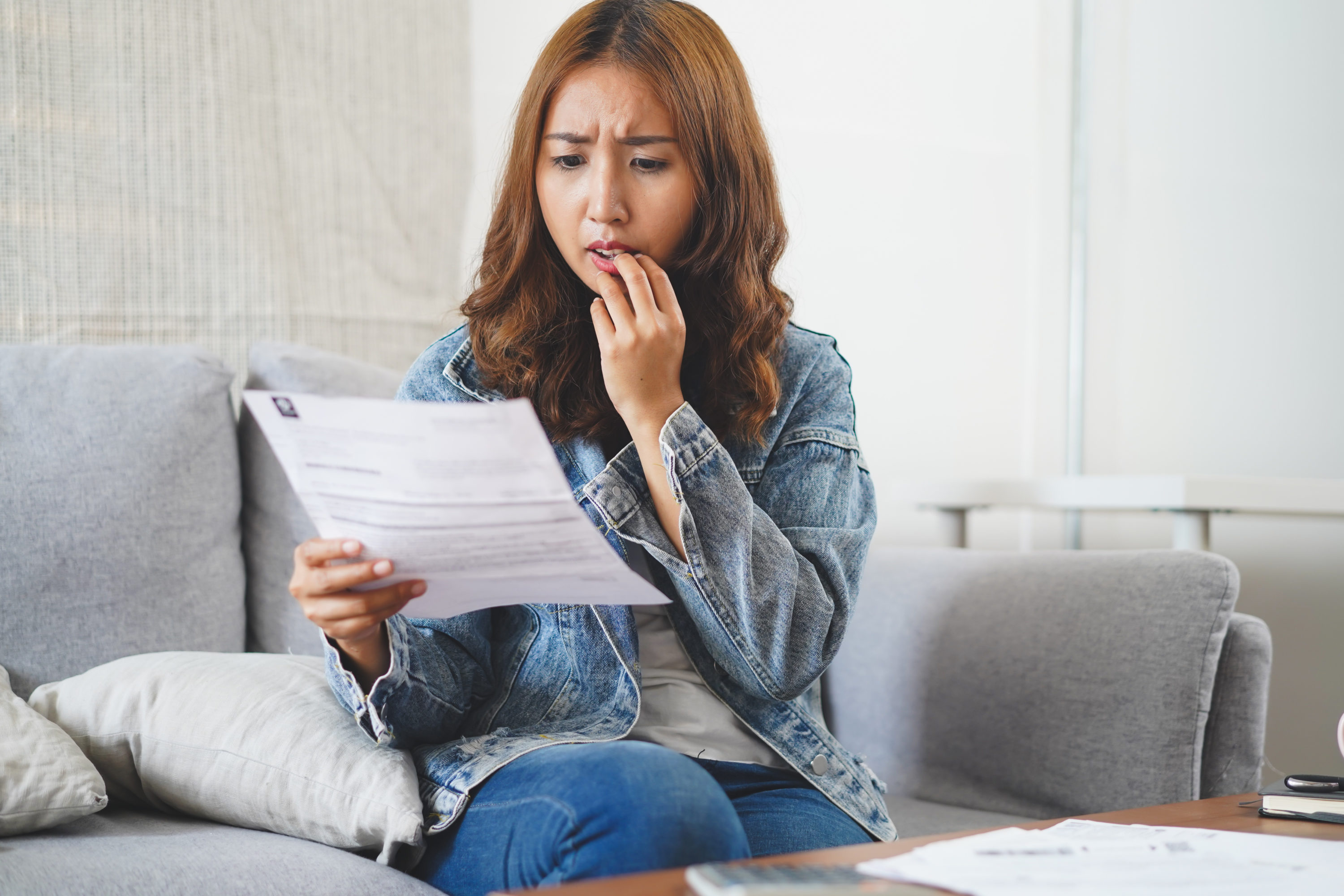 Young woman confused about credit report document Young woman confused about credit report document