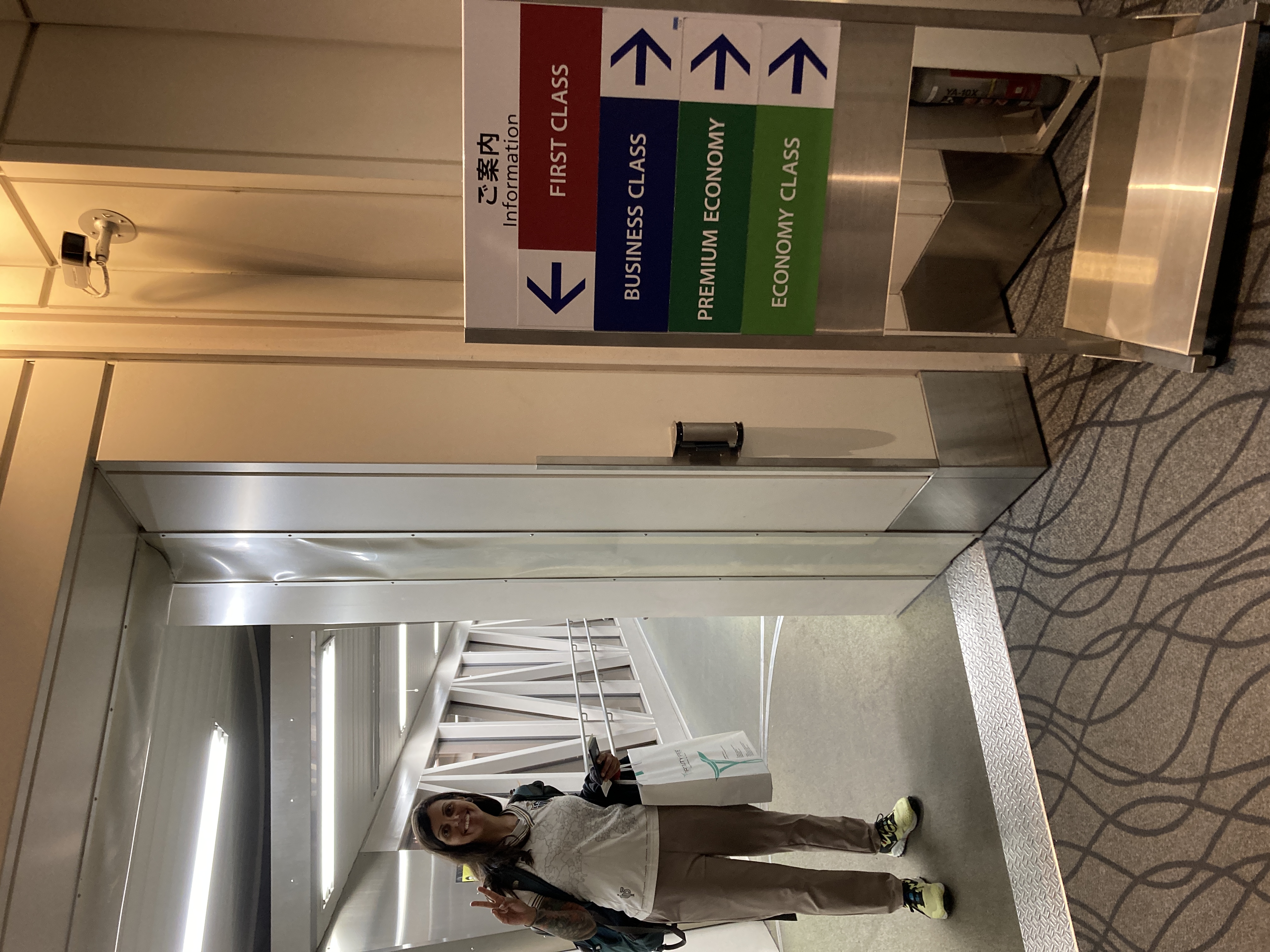 Woman near boarding signs indicating she is heading to the first-class cabin.