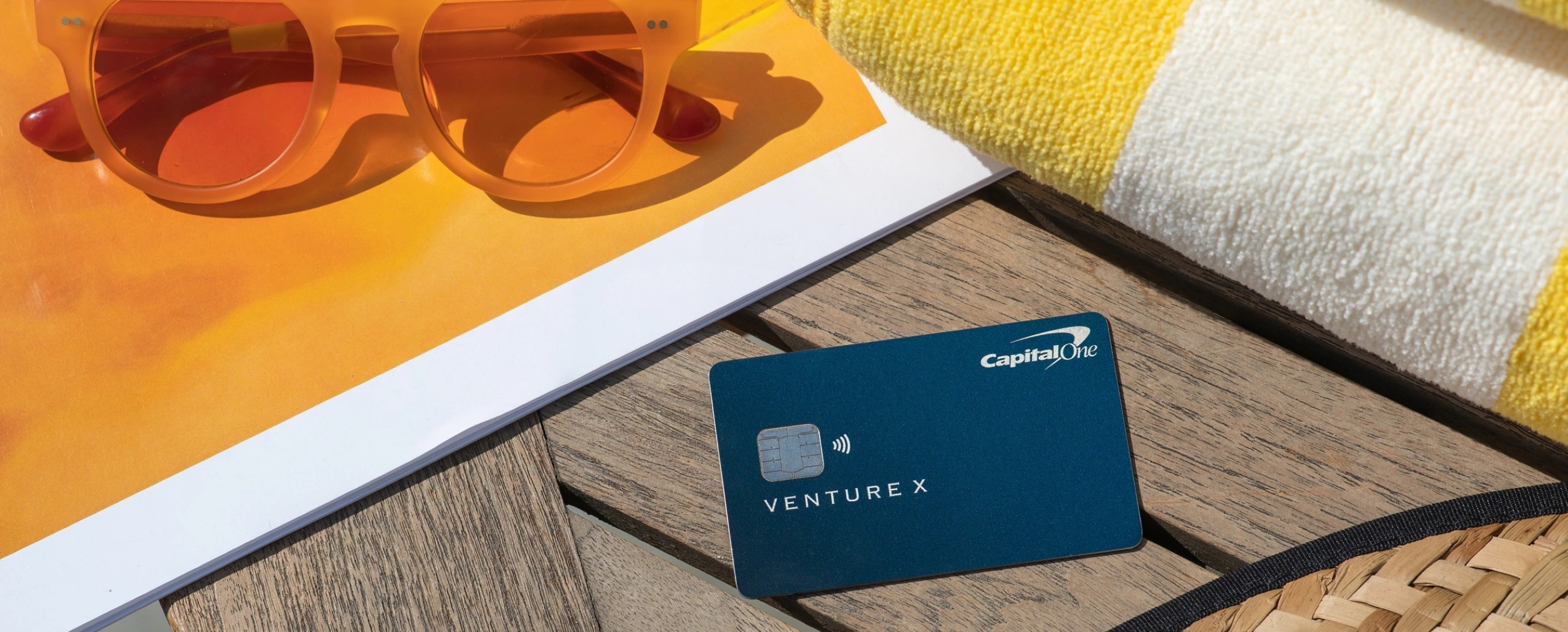 Capital One Venture X with sunglasses and towel Capital One Venture X with sunglasses and towel