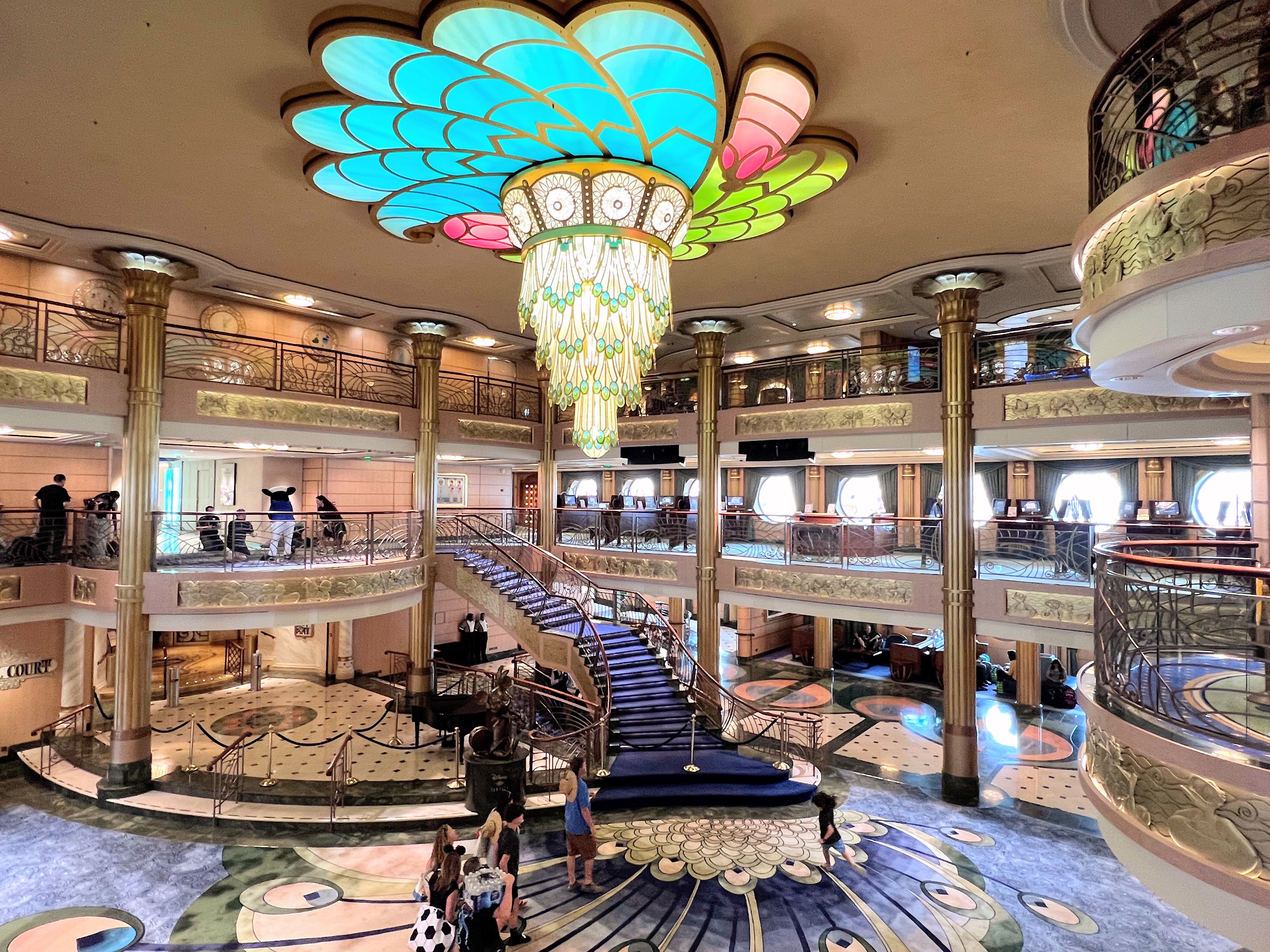 Family getting photo taken on Disney Cruise Lobby atrium on Disney Fantasy