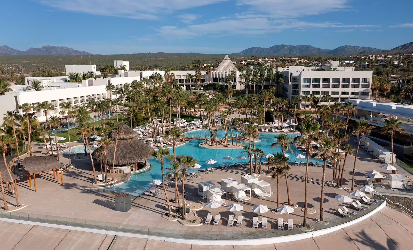 Paradisus Los Cabos The view of Paradisus Los Cabos's pool and hotel area surrounded by palm trees and ample lounge chairs.