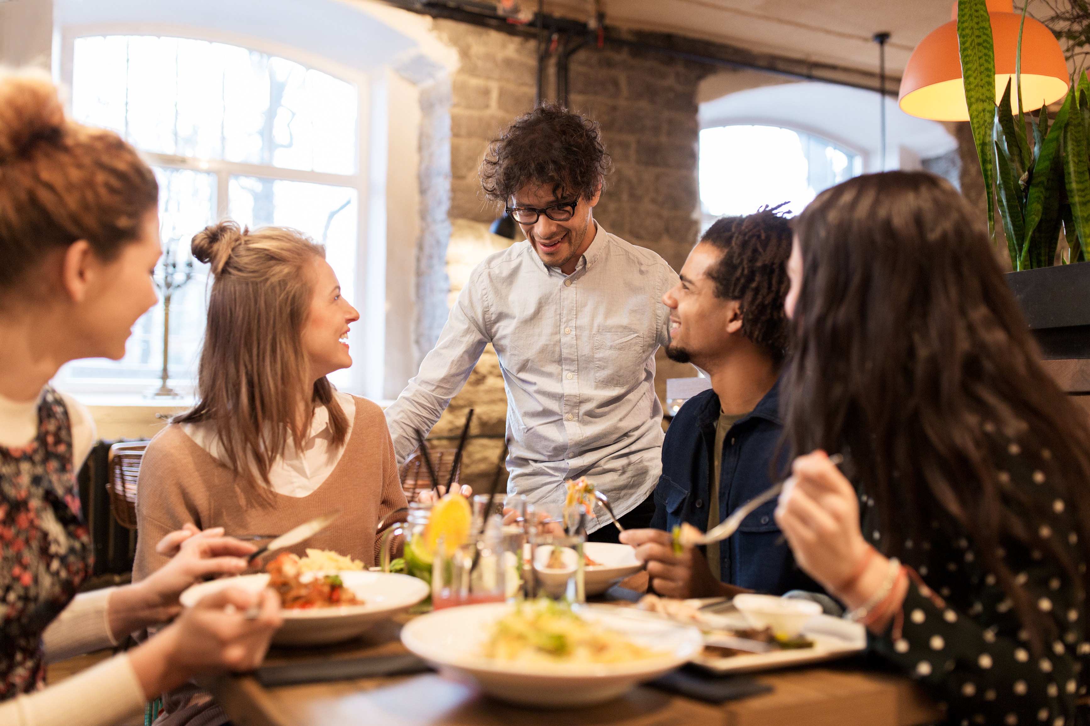 AdobeStock 138874507 happy friends eating and drinking at restaurant