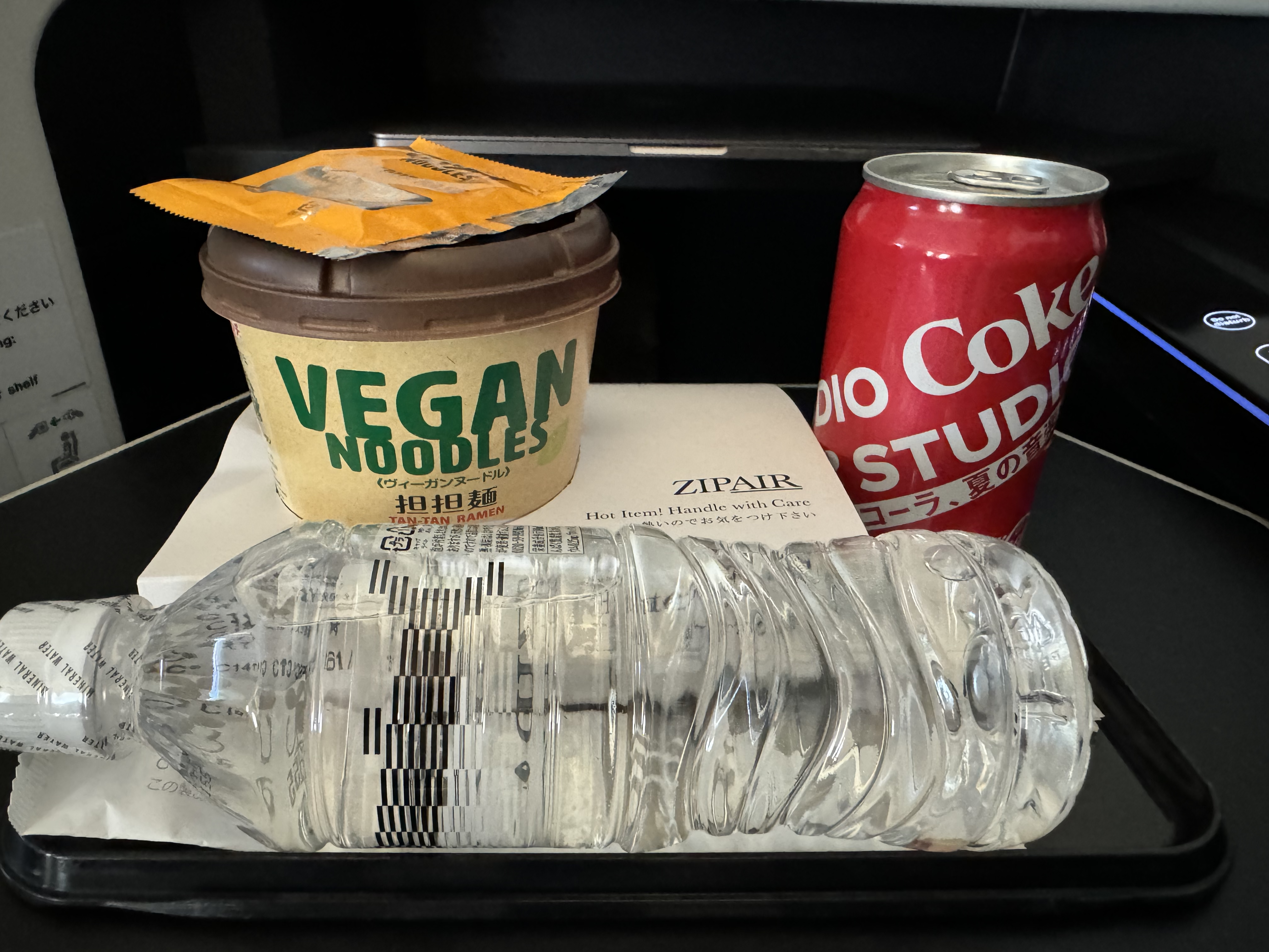 Zipair LAX NRT noodles coke water on tray Zipair LAX NRT noodles coke water on tray